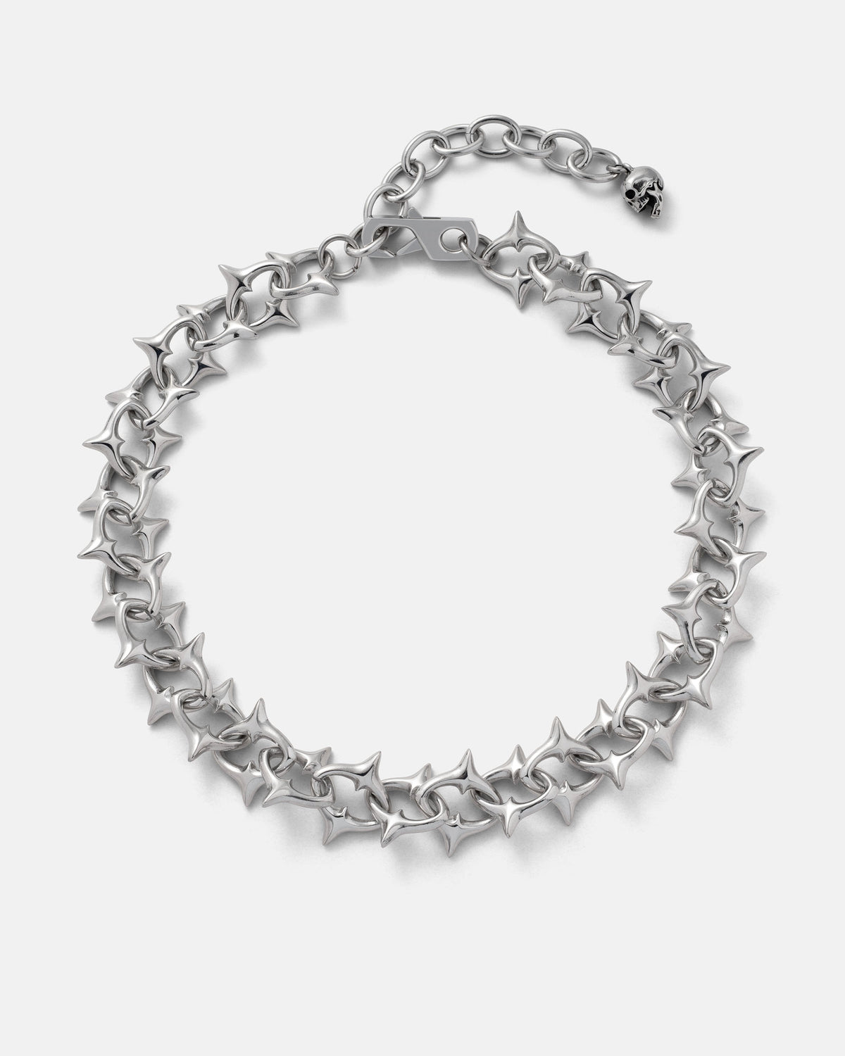 Introducing "The Cathedral" XL 15mm Spiked Chain by Statement Collective—a bold, silver gothic necklace crafted from stainless steel with interlocking spiked links designed to evoke barbed wire. Shown on a white background, this striking piece features an adjustable clasp and a distinctive skull charm at the end, adding an edgy statement to any look.