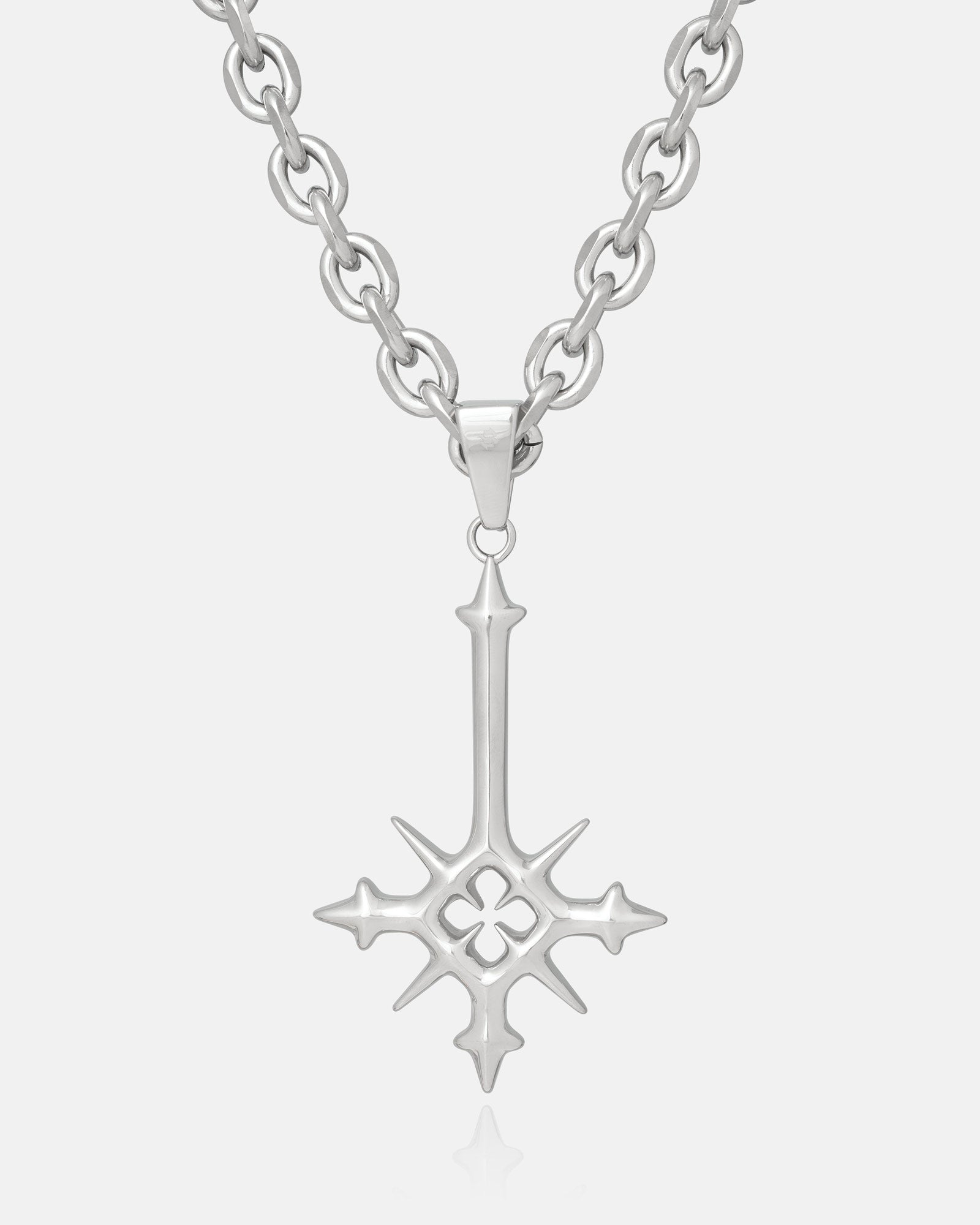 Silver necklace with a large star-shaped cross pendant on a white background by statement collective