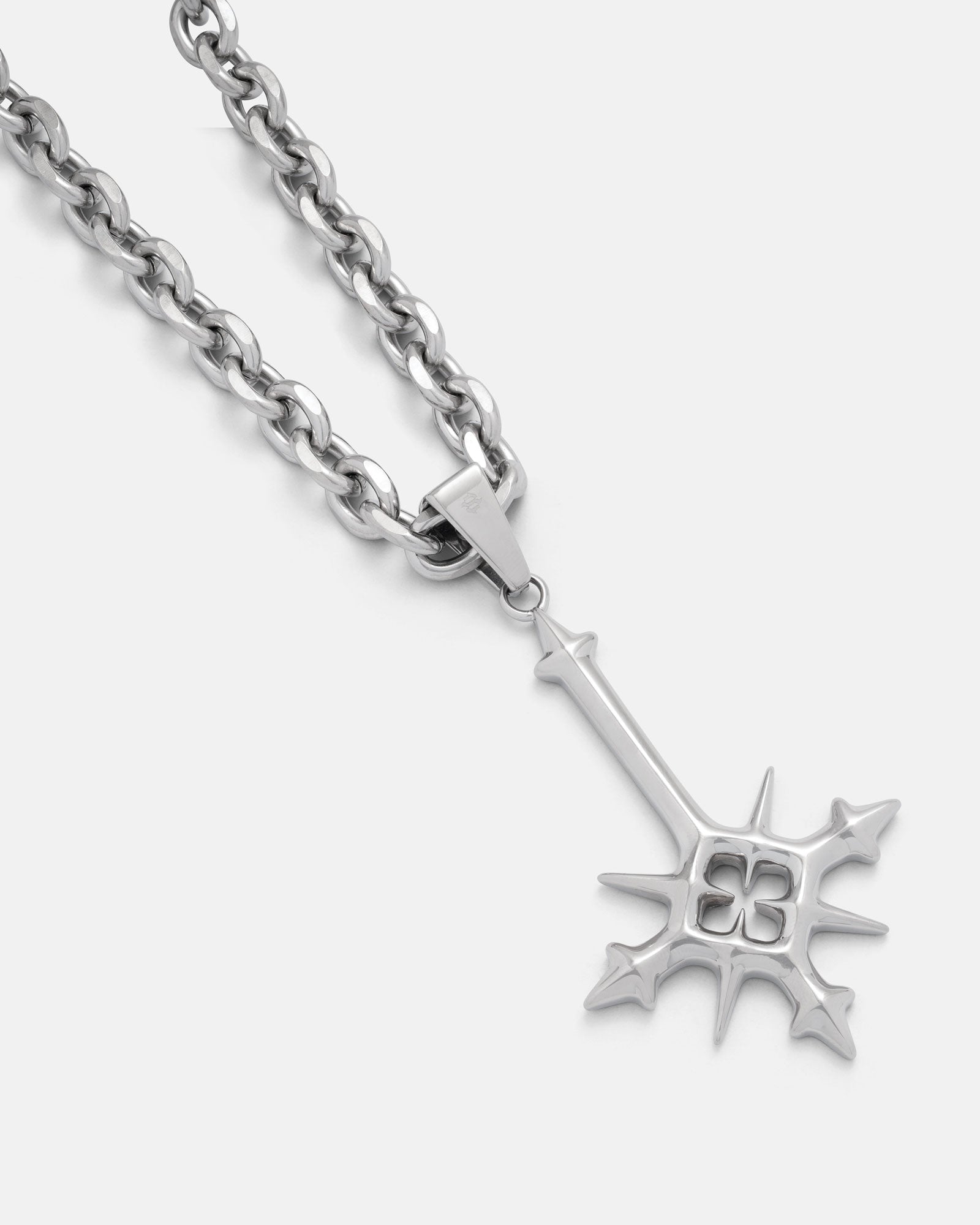 large inverted cross pendant with spikes on white background