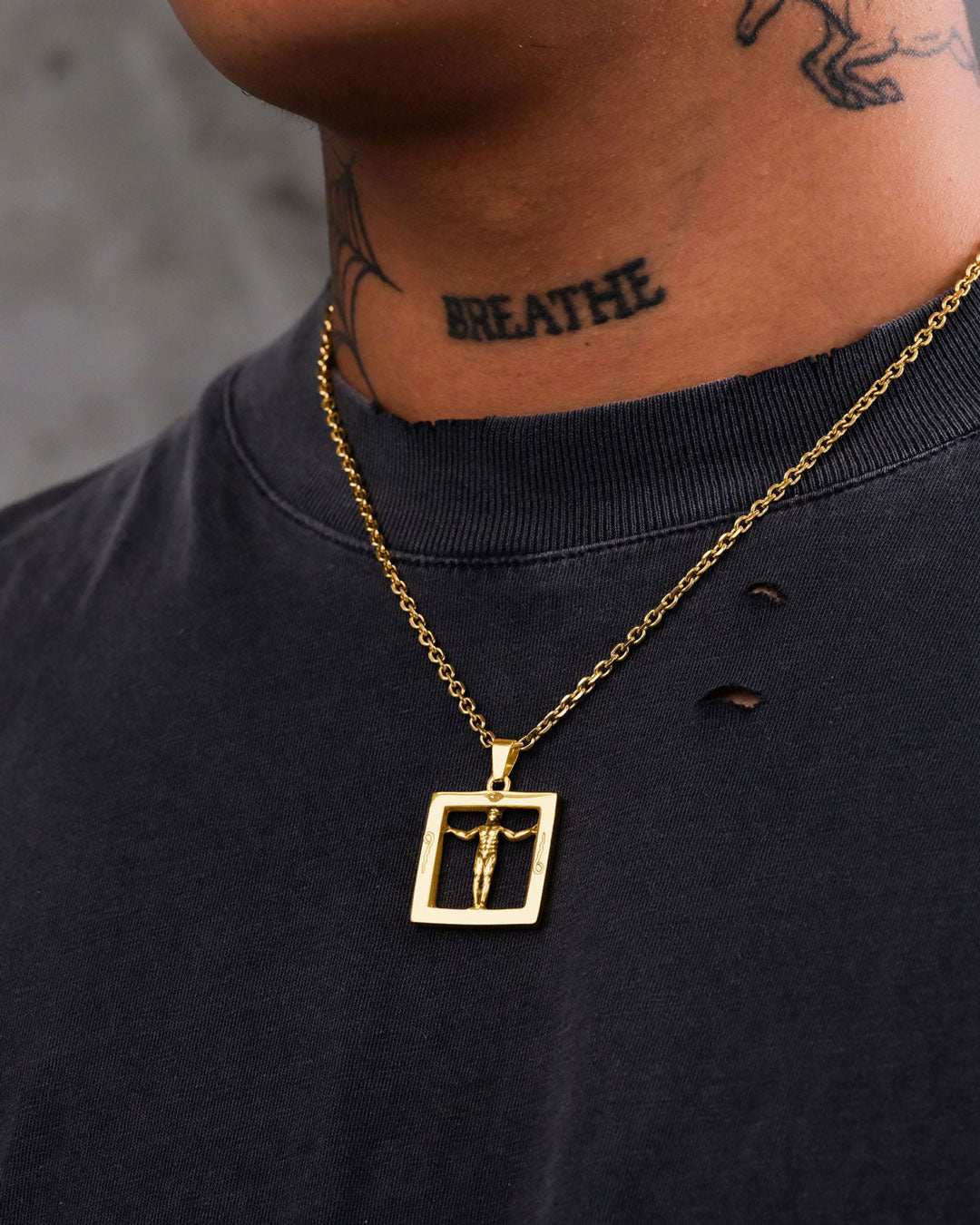 A close-up of a person wearing the Agrippa’s Square Pendant (Gold) styled as occult jewelry, with a black t-shirt featuring small holes and a BREATHE tattoo on their neck.