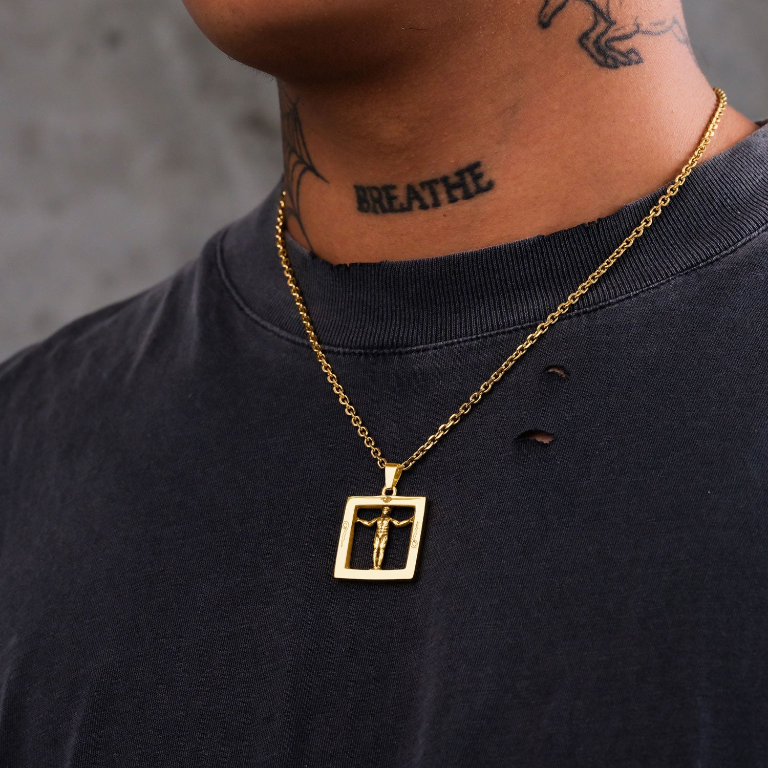 Gold chain with square pendant with man inside