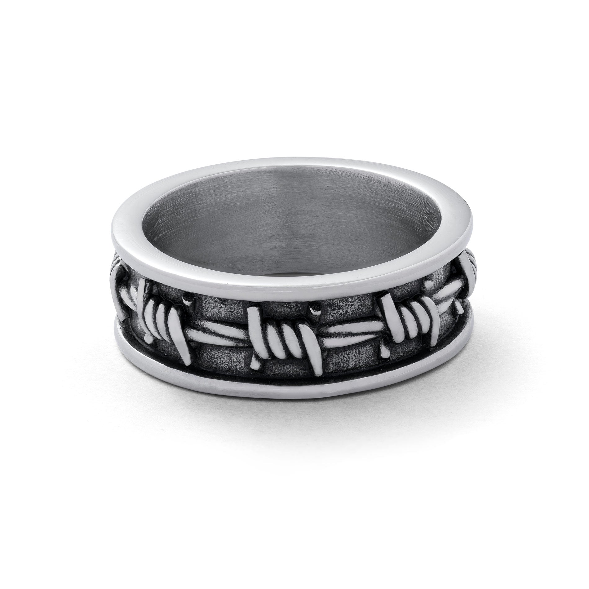 Silver ring with barbed wire details around entire ring.