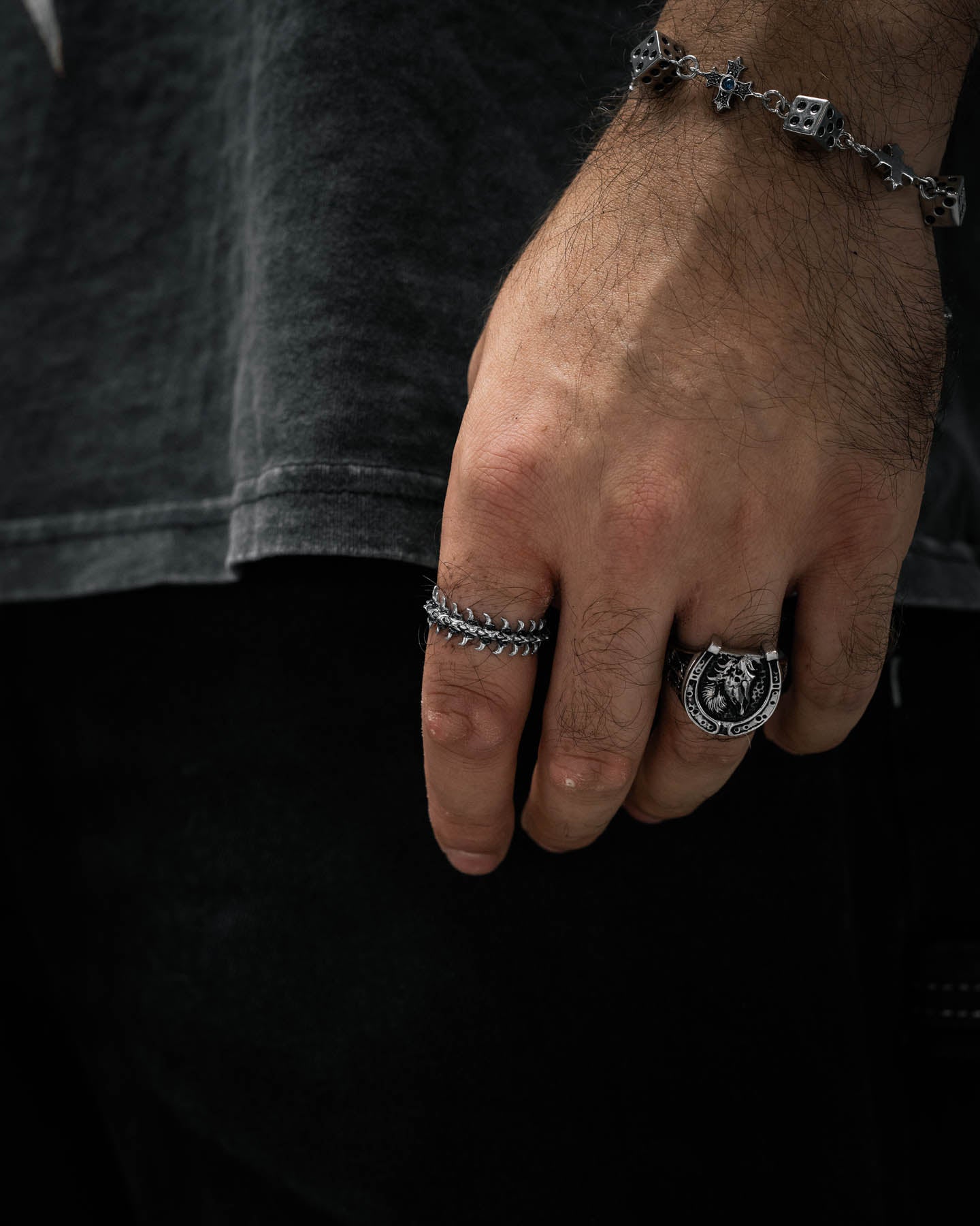 mans hand wearing band ring with fishbone pattern around the design by statement collective