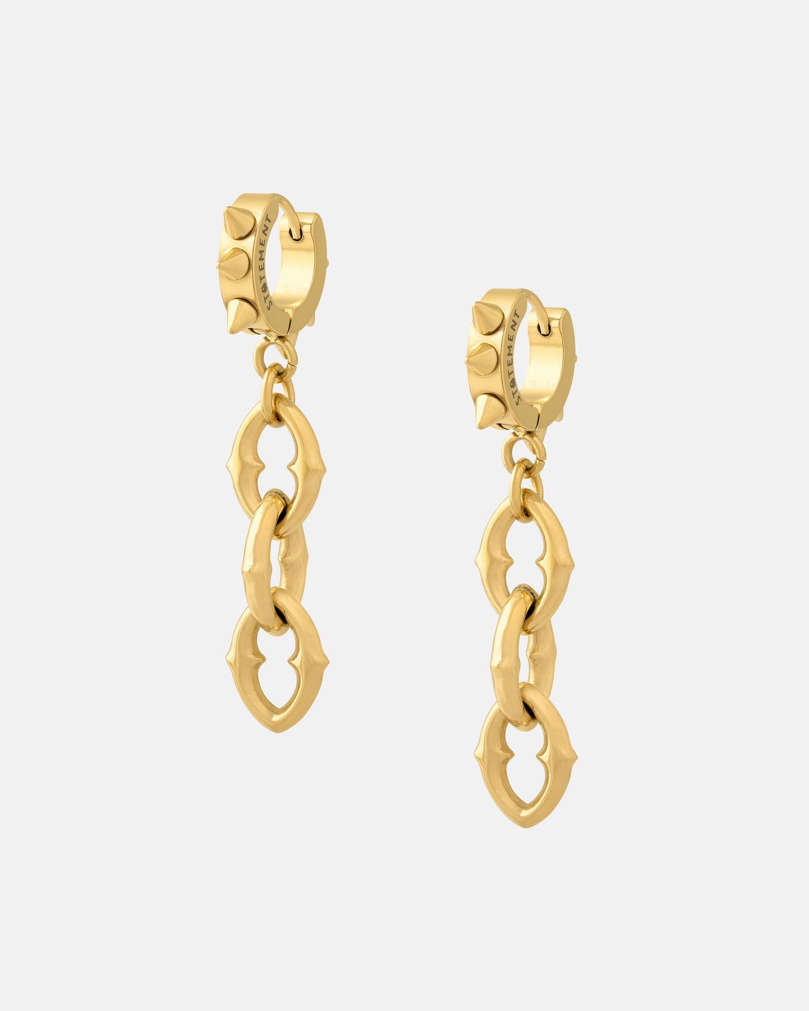 The Cathedral" 9mm Chain Earrings (Gold) feature chunky, spiked link chains with rounded, angular shapes dangling from textured, ridged hoop studs, displayed on a plain white background.