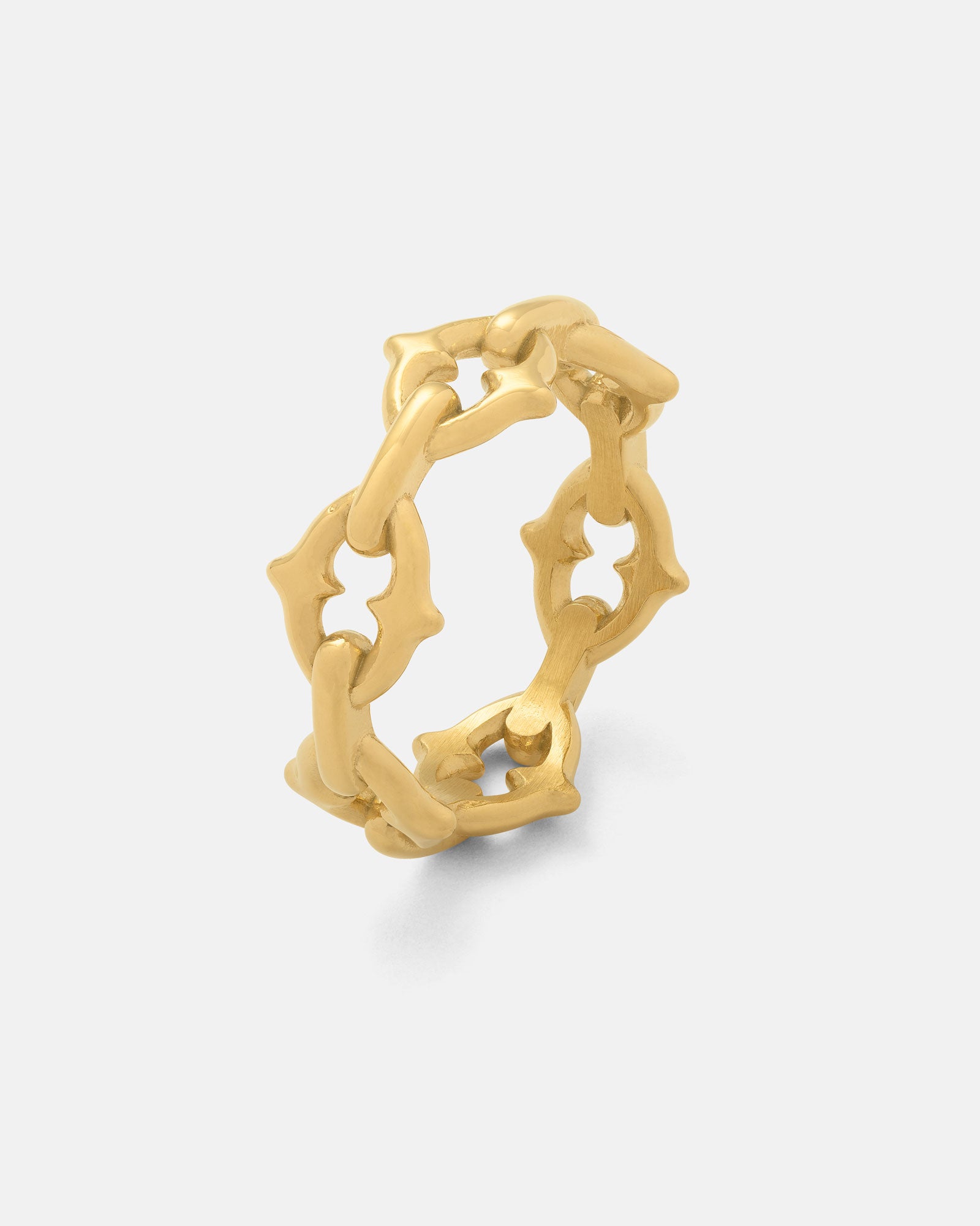 Crafted in 18k gold, "The Cathedral" Spiked Ring features interlocking links with star-shaped cutouts for a bold, elegant look. Shown on a plain light background, this gothic-inspired piece makes a striking statement.