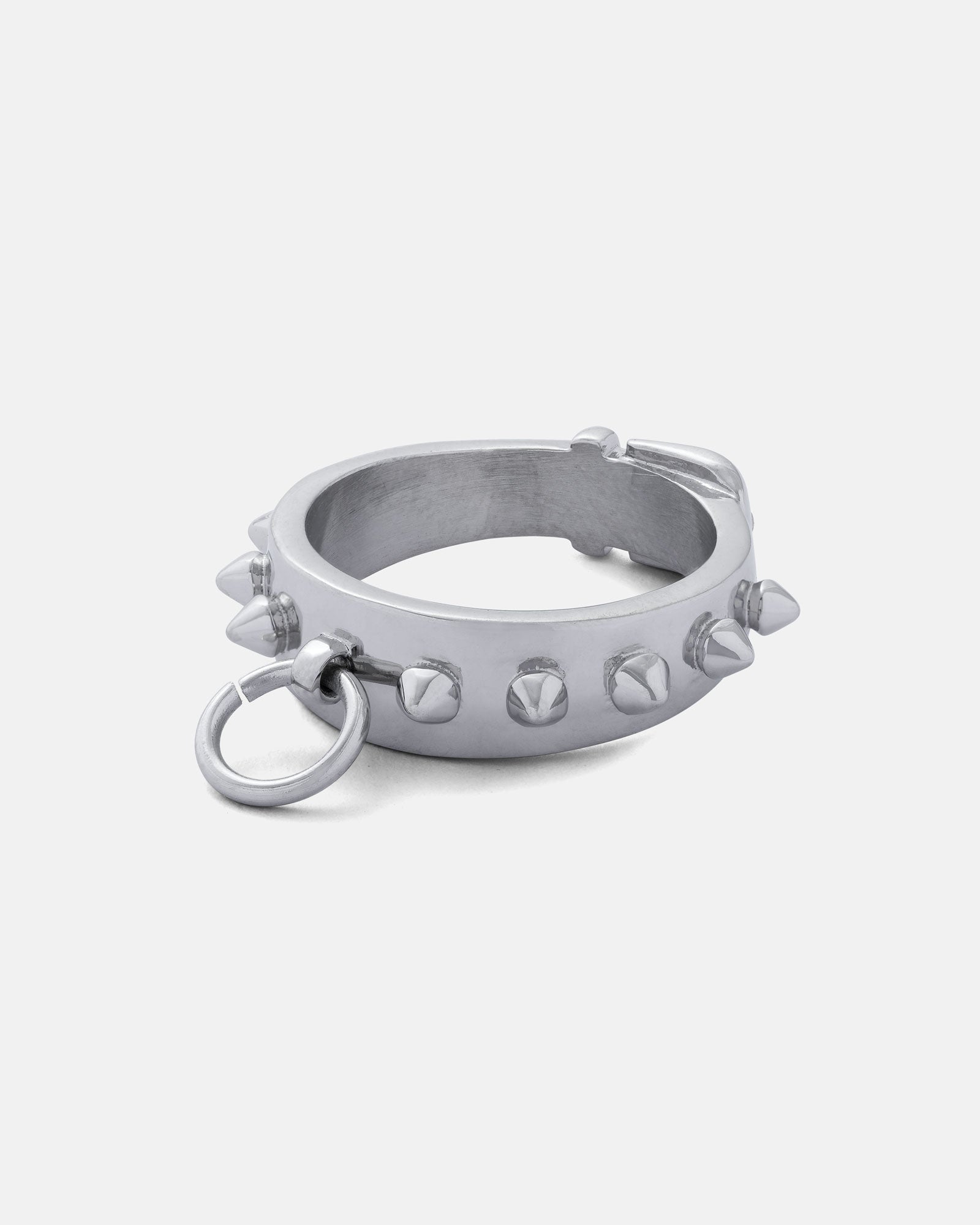 The Spiked Dog Collar Ring is a silver, circular bracelet inspired by goth jewelry, featuring pyramid studs and a small stainless steel ring on its side, shown against a plain white background.