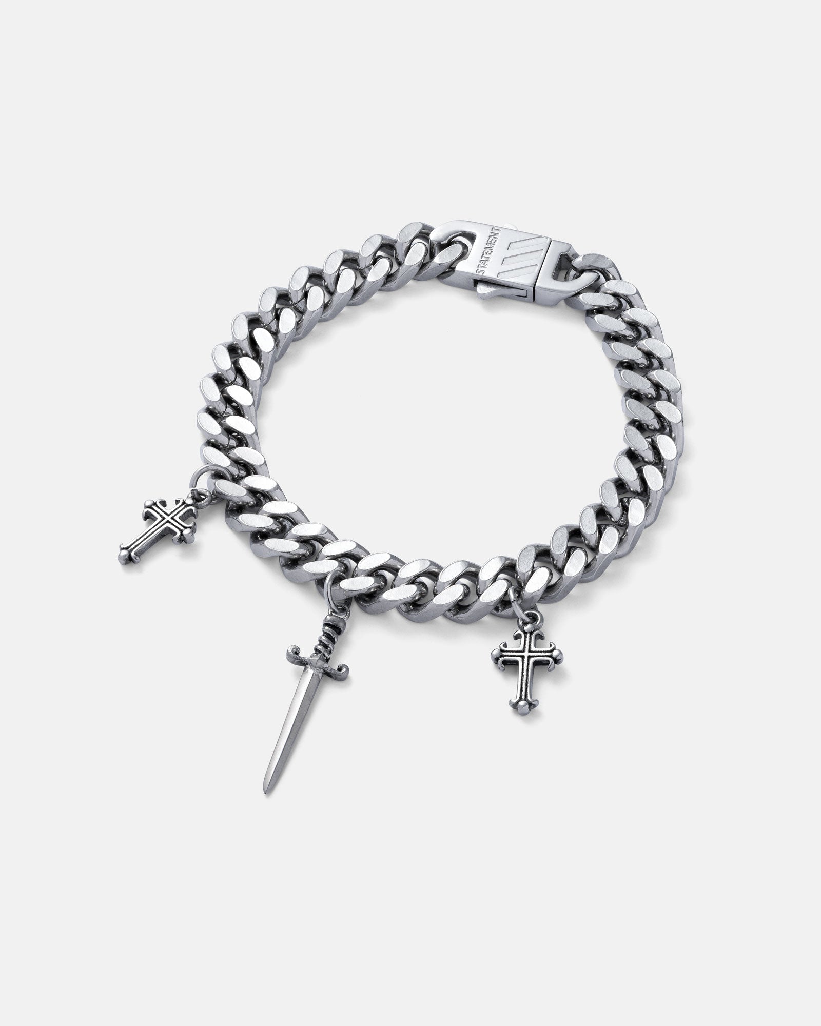 9mm Cuban link bracelet with hanging dagger charm in the center as well as 2 french cross charms on either side, all in silver by statement collective on grey background.