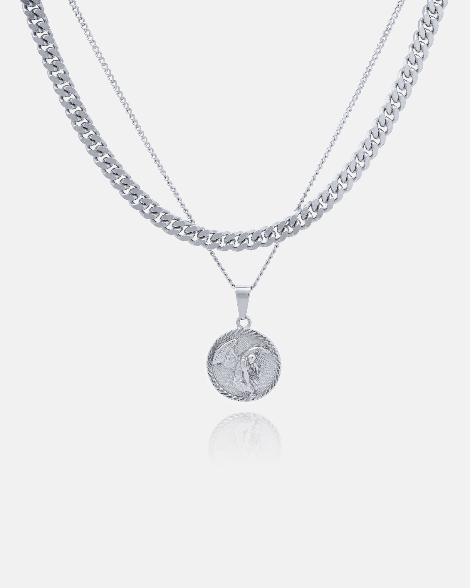 The Cuban Set (Custom Pendant Choice) includes three layered silver necklaces: a thick Cuban link chain, a thin chain, and a thin chain with your choice of engraved round pendant, all displayed on a white background.