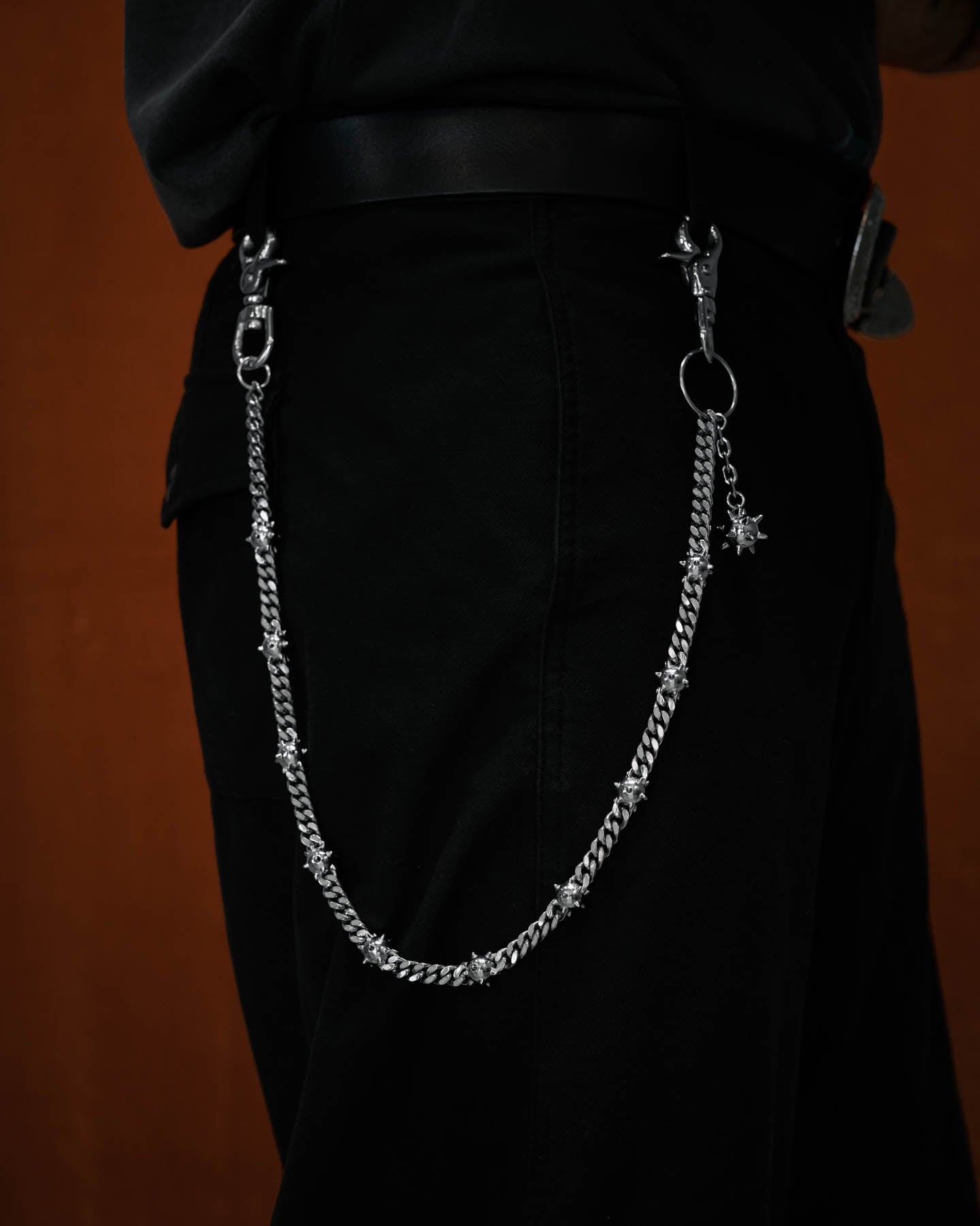 man with black pants wearing cuban link wallet chain with spiked mace balls interlinked