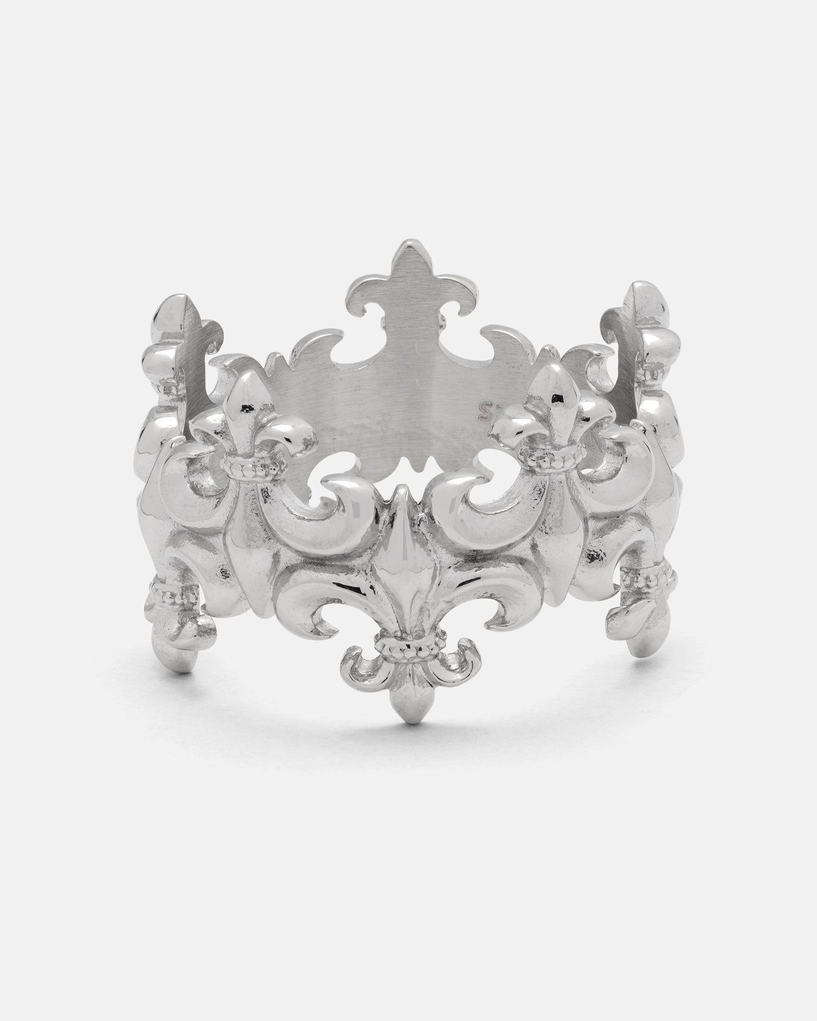 Expertly crafted from durable 316L stainless steel, the “Crested” Fleur De Lis Ring by Statement Collective showcases intricate fleur-de-lis designs and ornate decorative patterns on a crown-inspired band, presented against a plain white background.