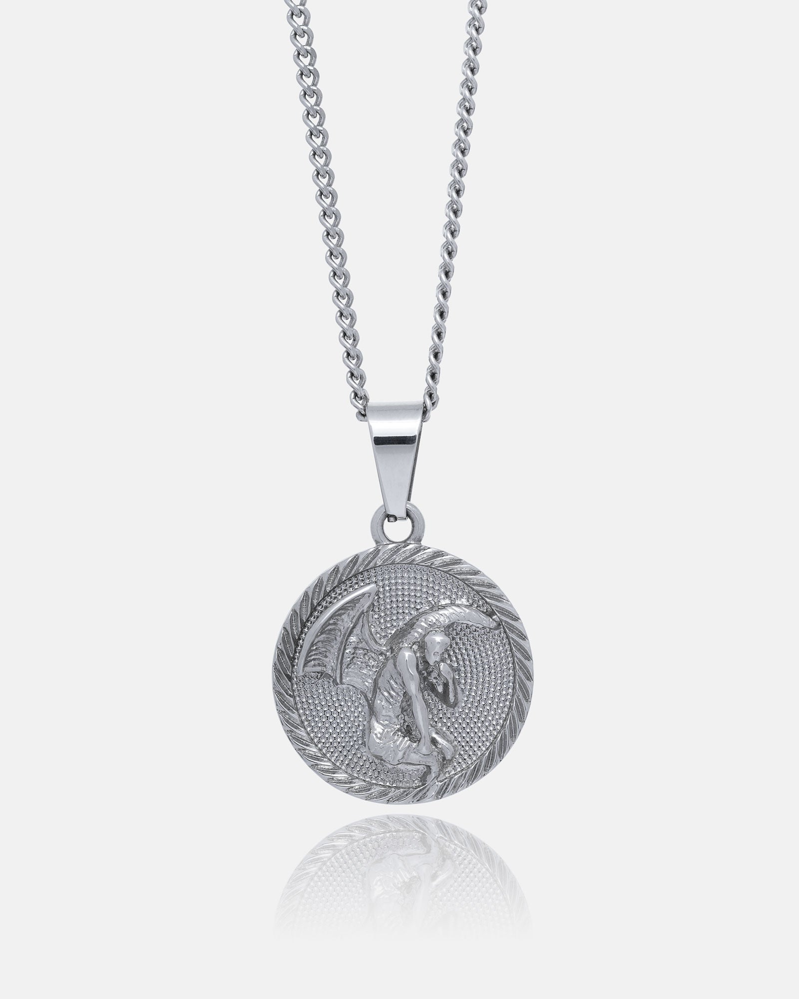 The Fallen Angel Medallion Pendant is a silver necklace with a round, engraved seated angel and laurel wreath design, hanging from a simple chain and displayed on a plain white background.
