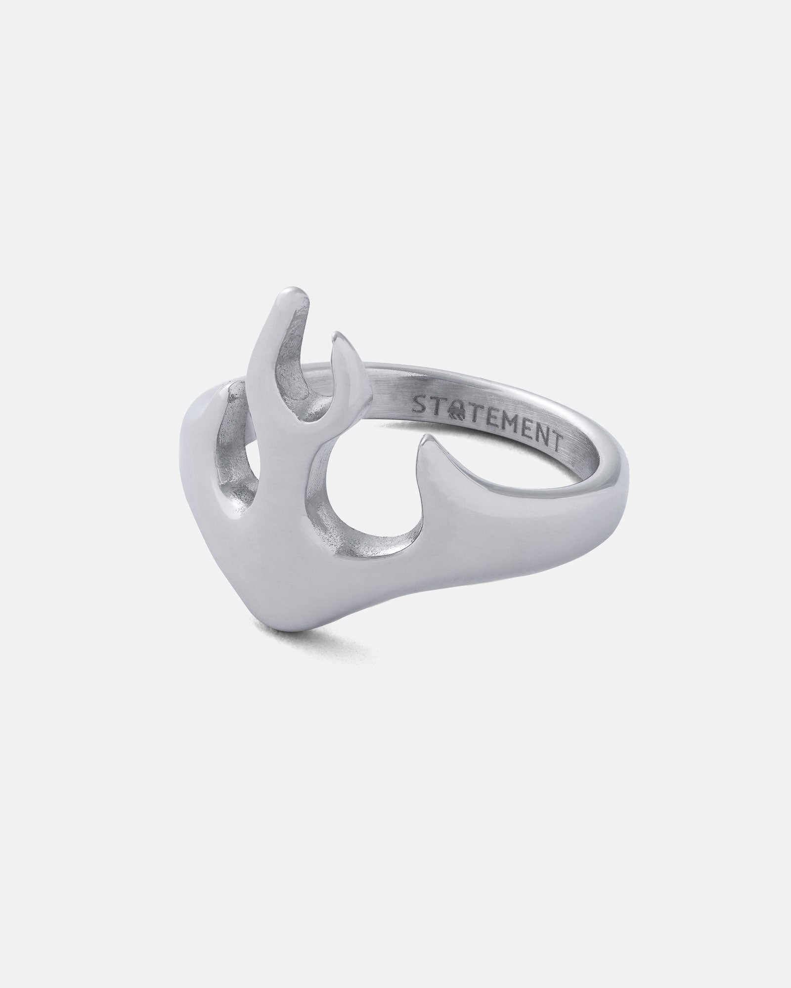The Flame Ring is a silver, stainless steel piece with an abstract, open flame-inspired design and "STATEMENT" engraved inside. This bold streetwear accessory is shown on a plain white background.