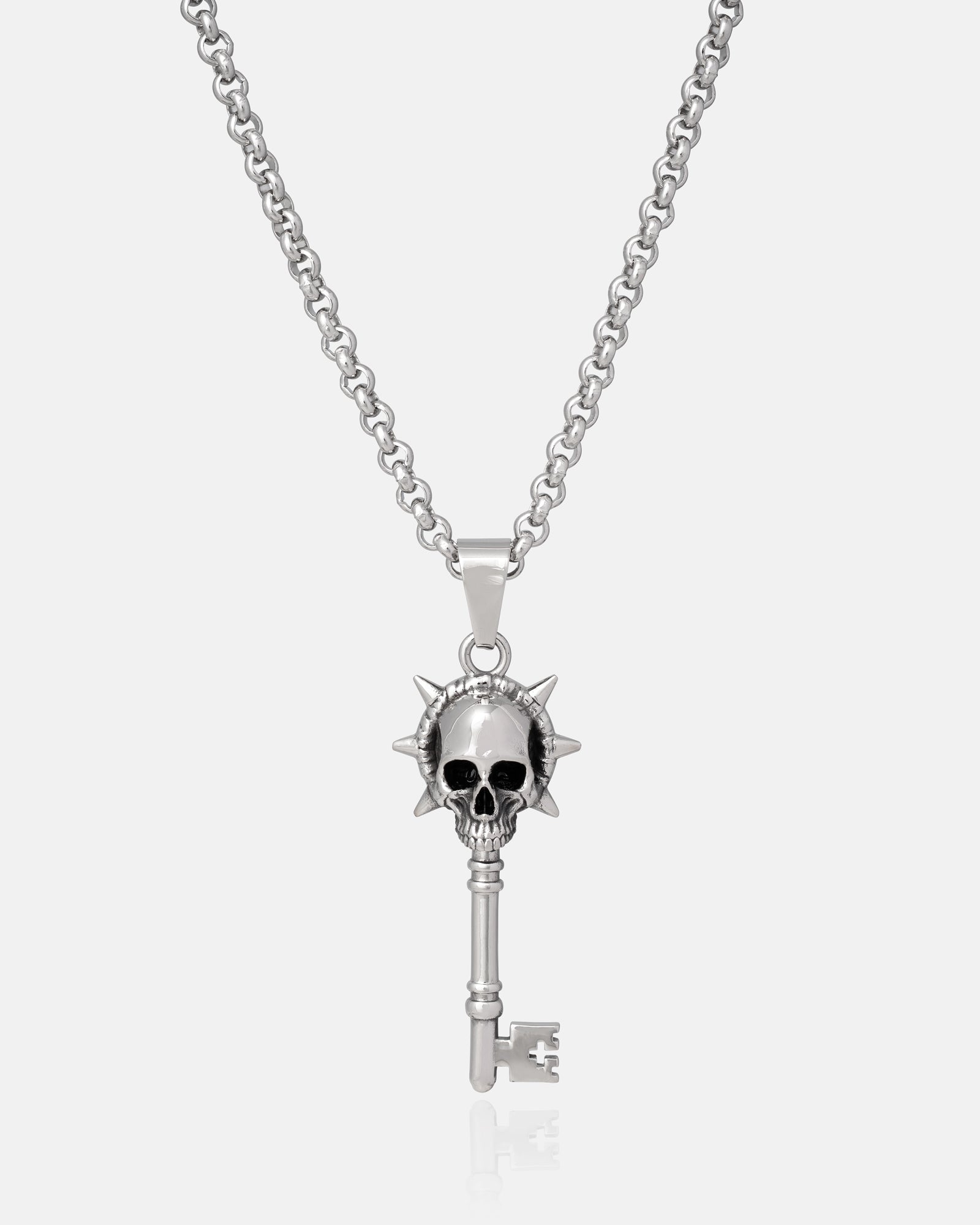 Silver key-shaped pendant with skull design on a chain hanging against a white background