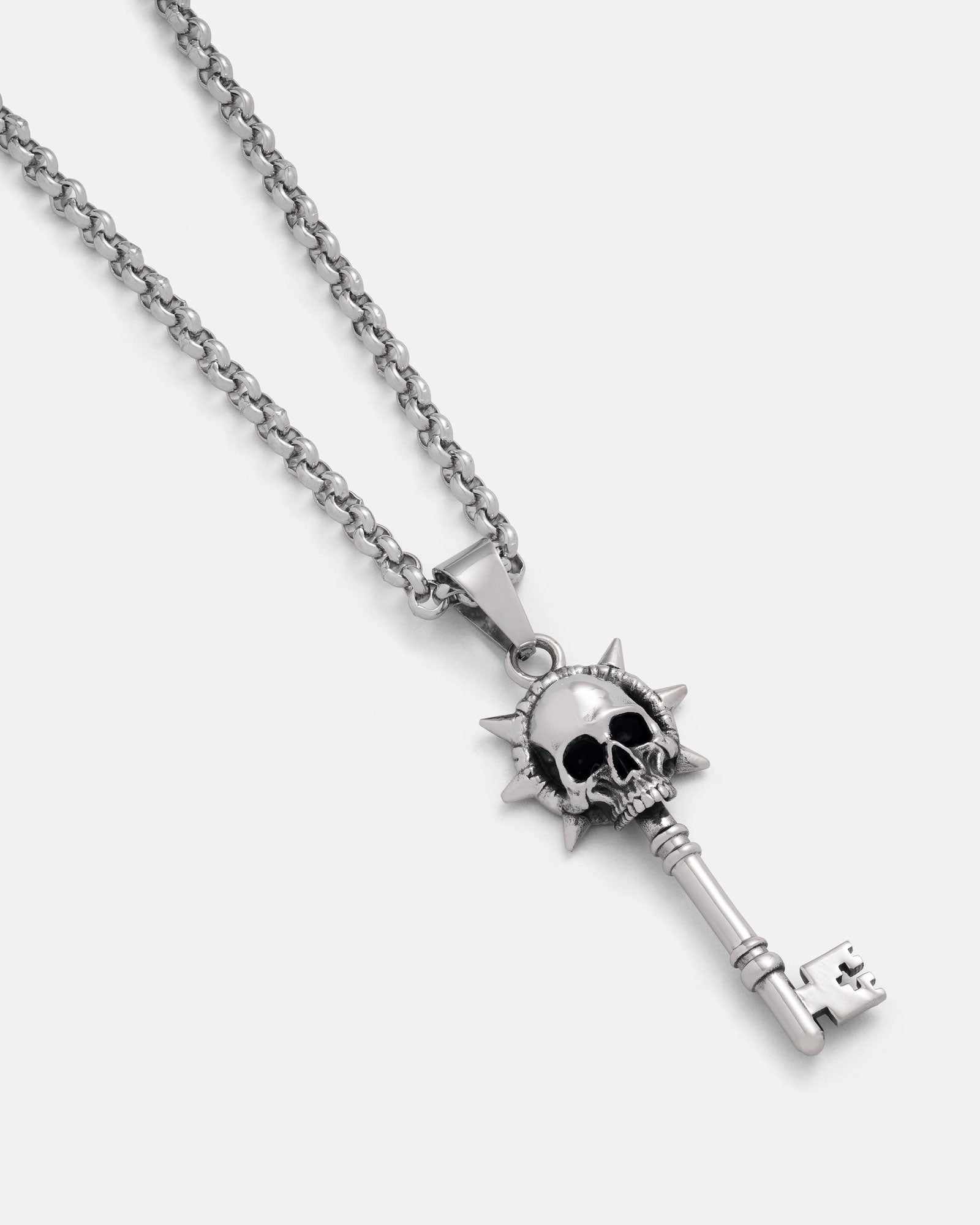 Silver key-shaped pendant with skull design on a chain against a white background