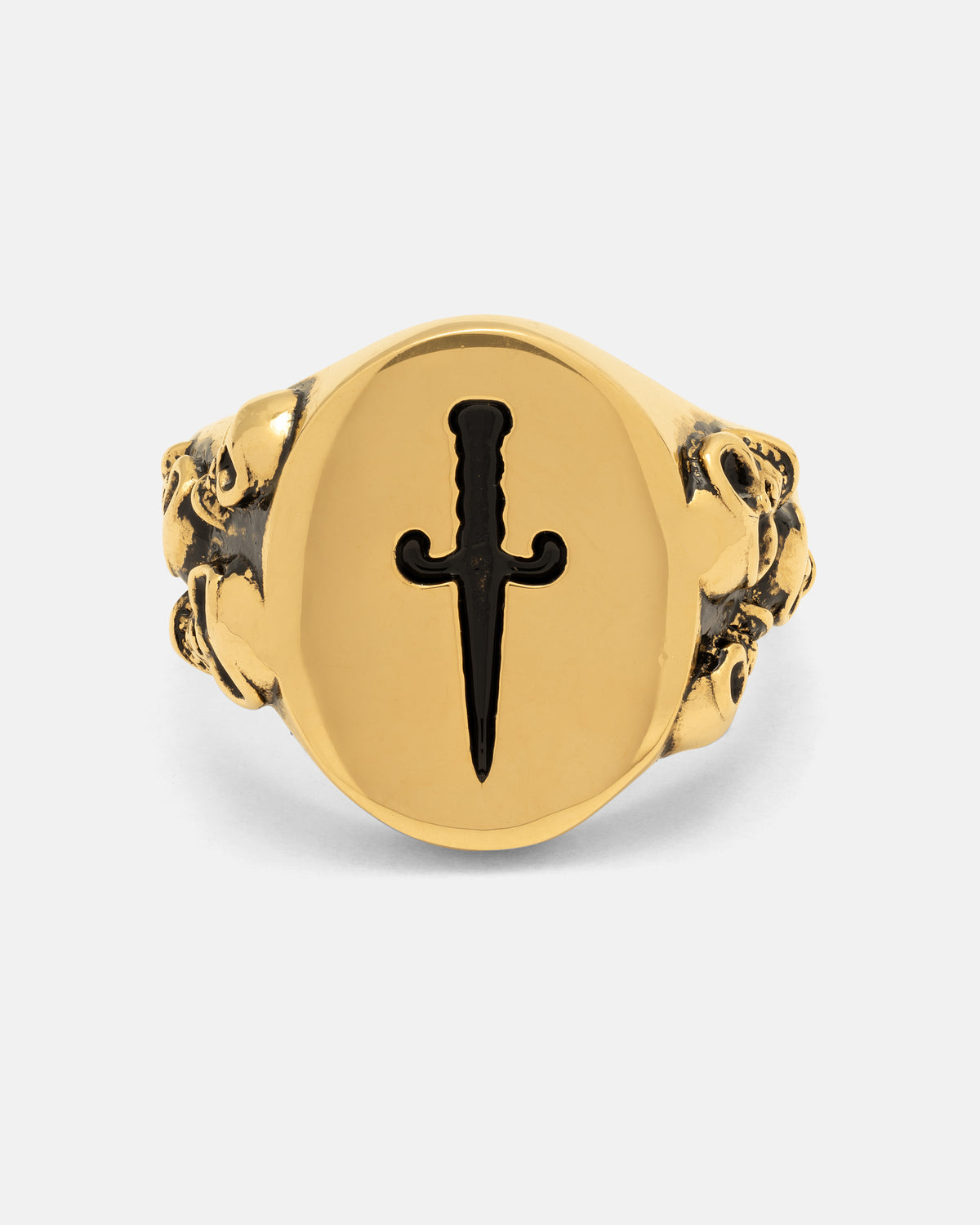 The Graveyard Signet Ring (Gold) by Statement Collective features a bold flat oval face engraved with a black dagger, perfectly capturing the essence of gothic jewelry. Intricately sculpted lion heads grace both sides of the 18k gold band, lending an air of mystery and striking sophistication to this unique piece.