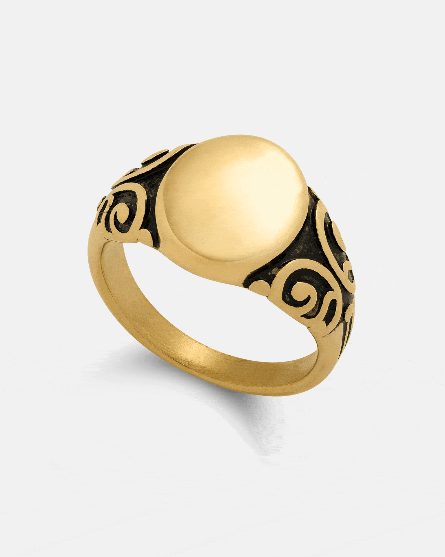 The Statement Collective Mini Oval Scroll Signet Ring (Gold) showcases a sleek, oval top with intricate black scrollwork along the band, elegantly displayed on a plain white background. Expertly crafted from 18k gold, this signet ring combines enduring quality with sophisticated design.