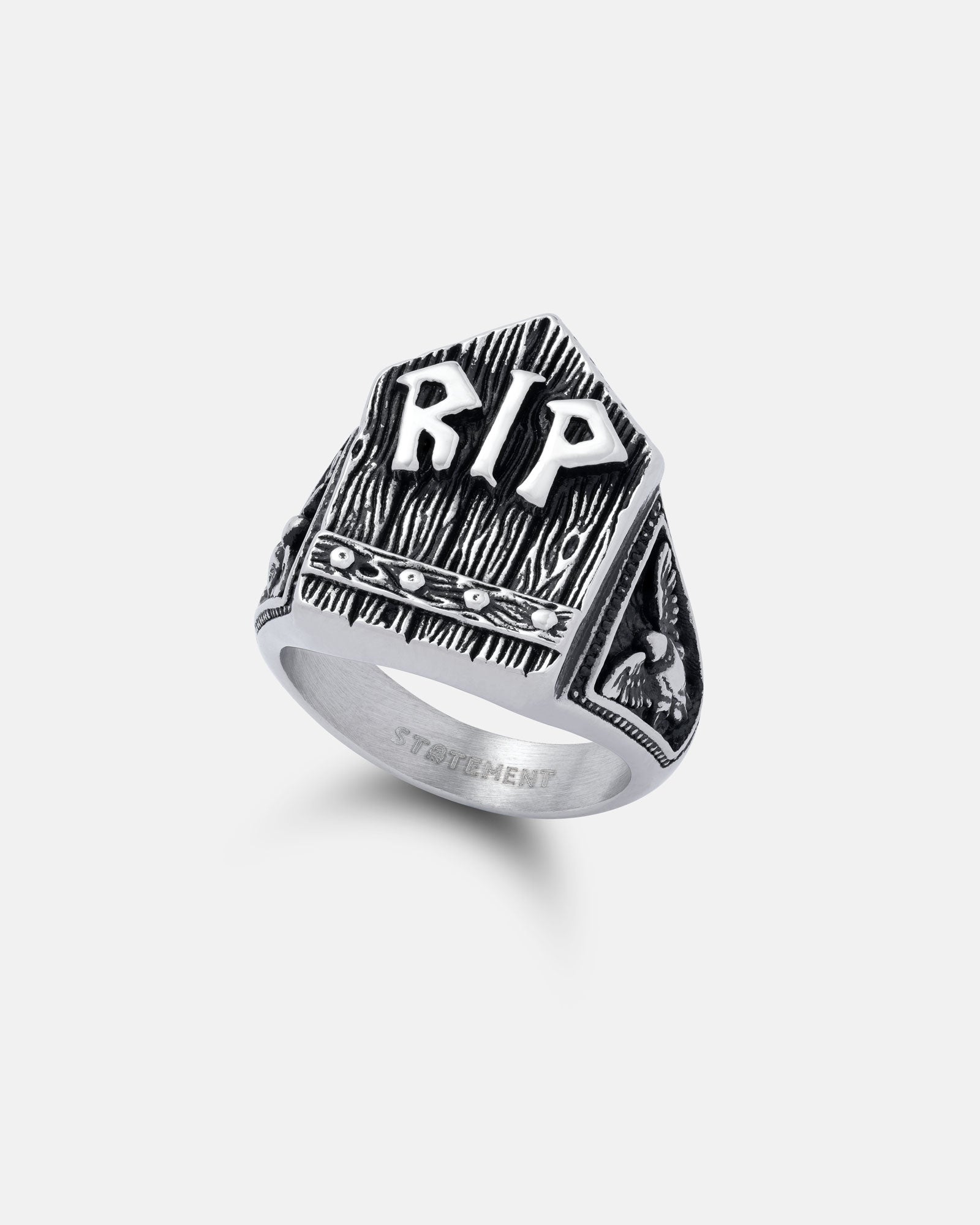 The Gravestone Ring is a silver macabre jewelry piece shaped like a tombstone with raised RIP letters on the front, engraved details, and a small skull design on the side.