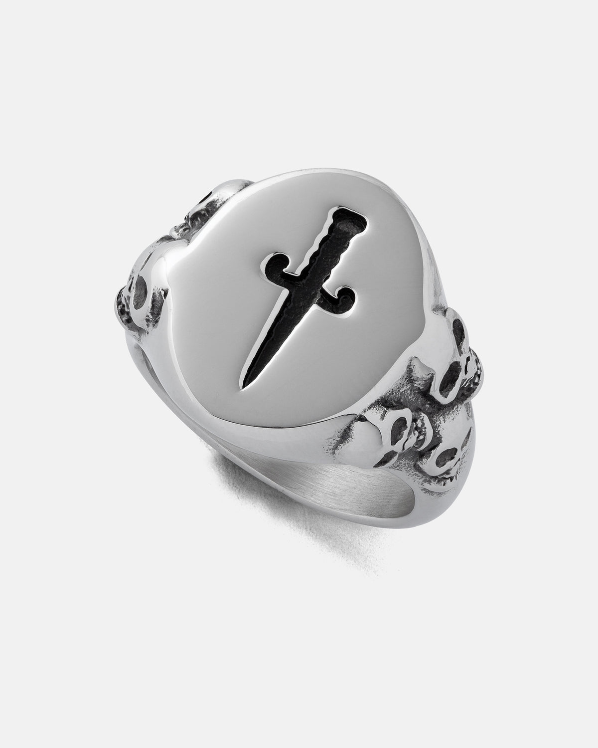 The Graveyard Signet Ring by Statement Collective is a silver skull ring featuring a bold black dagger design on the face and engraved skulls along the sides, set against a plain light background.