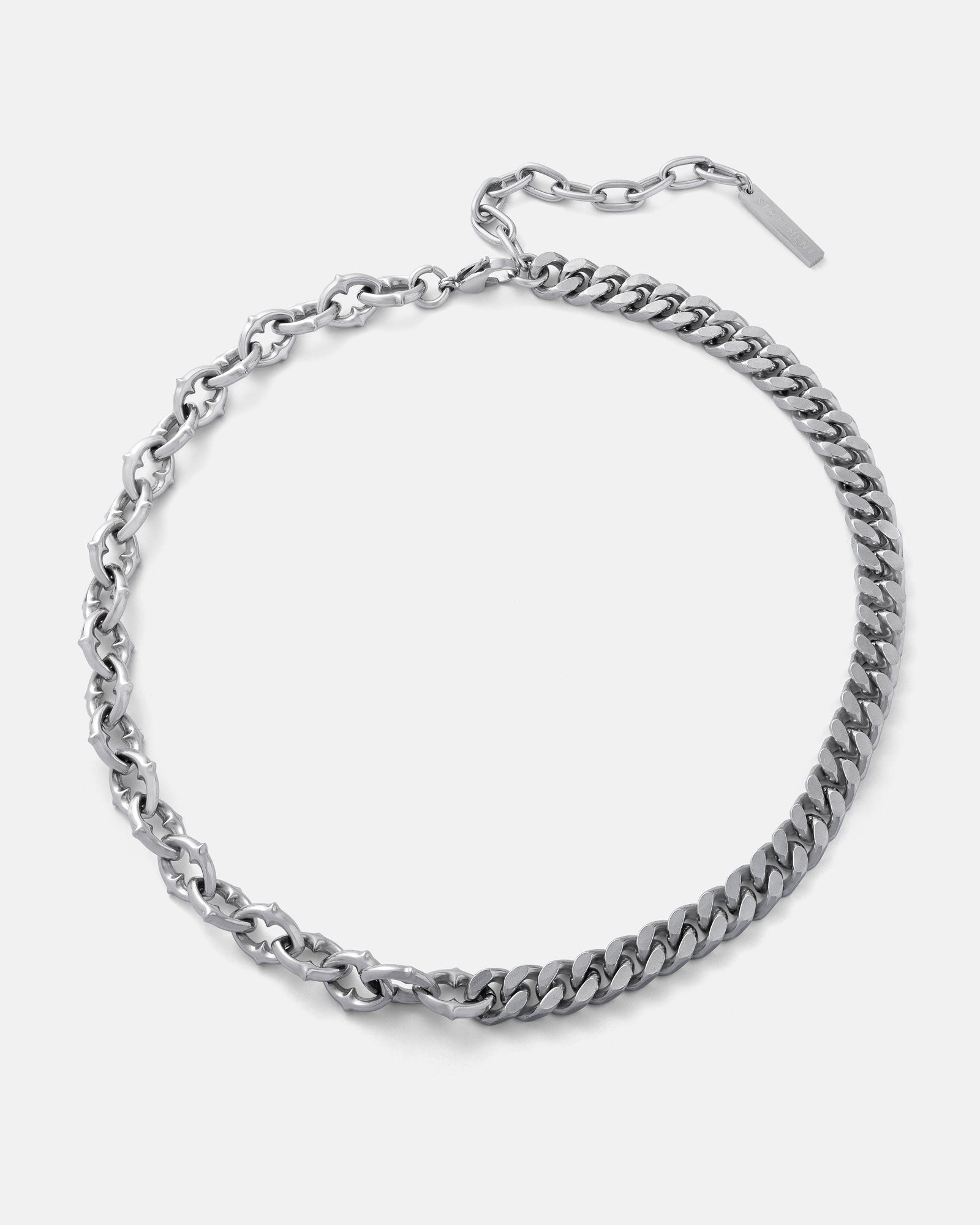 The "Split" Cathedral Cuban Chain (Adjustable) features gothic flair with one side of rounded, intricate links and the other of flat, rectangular links, finished with an adjustable clasp for a distinctive silver necklace.