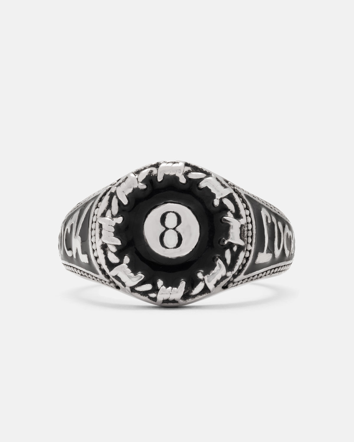 Statement Collective Lucky Shot ring, a stainless steel 8-ball design with a central black emblem, barbed wire detailing, and the word LUCK engraved.
