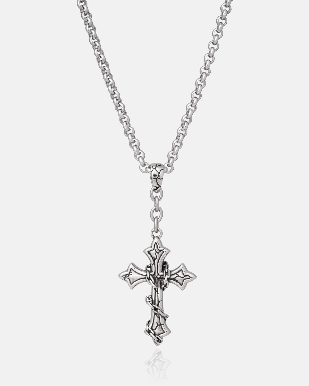 Mini “The Ruins” Cross Pendant by Statement Collective—a stainless steel necklace showcasing an ornate gothic cross with pointed edges and an intertwined design. Displayed against a plain white background, this striking piece effortlessly merges classic elegance with modern style.