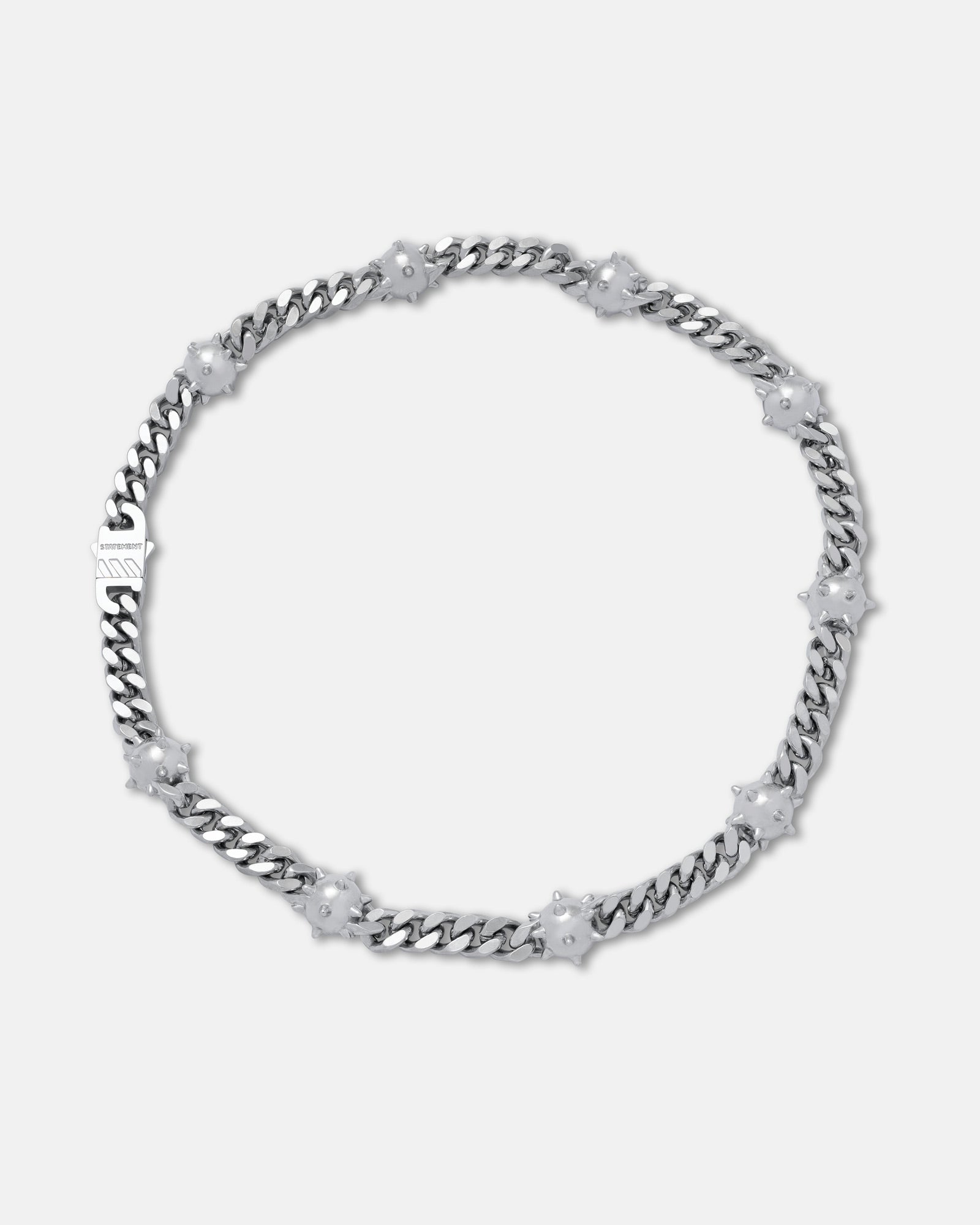 The "Morning Star" Cuban Chain is a silver necklace featuring star-shaped white floral accents, evenly spaced along its stainless steel chain, shown on a plain light grey background.