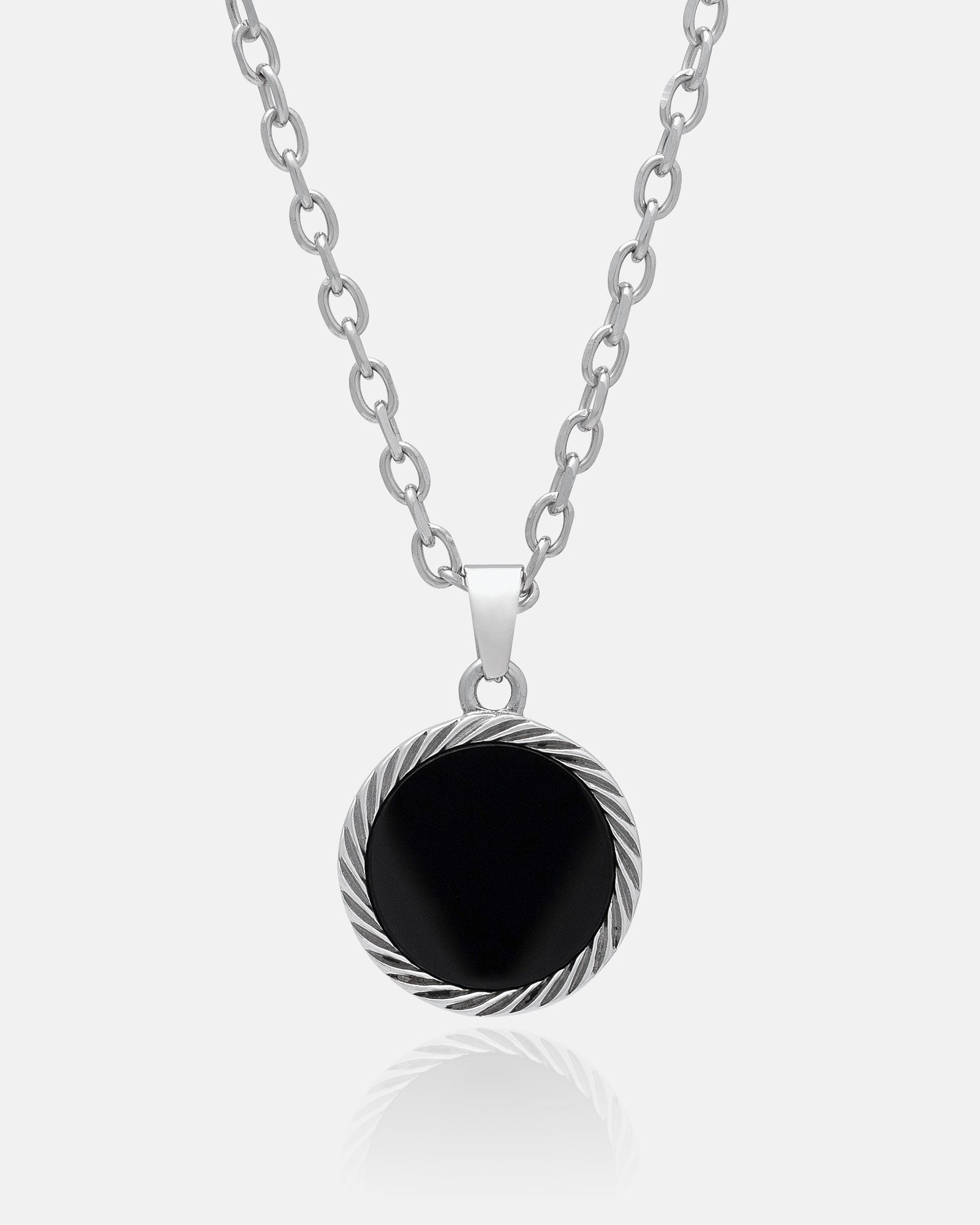 The Onyx Medallion Pendant features a silver chain and a round black agate onyx centerpiece framed by a twisted, rope-like silver border, shown against a plain white background.