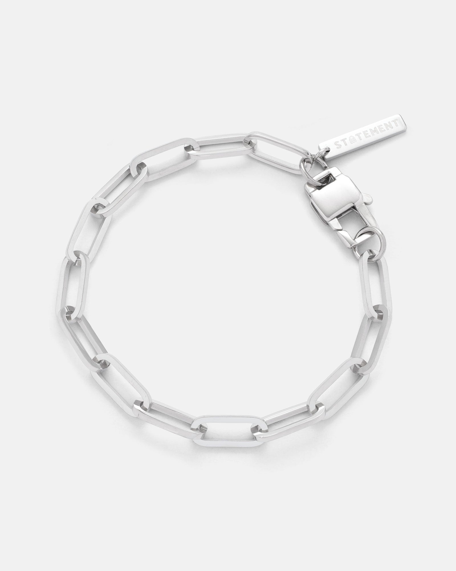 The Paperclip Bracelet features elongated rectangular stainless steel links and a rectangular STATEMENT tag by the clasp. Non tarnish, modern, and durable, it’s displayed on a white background.