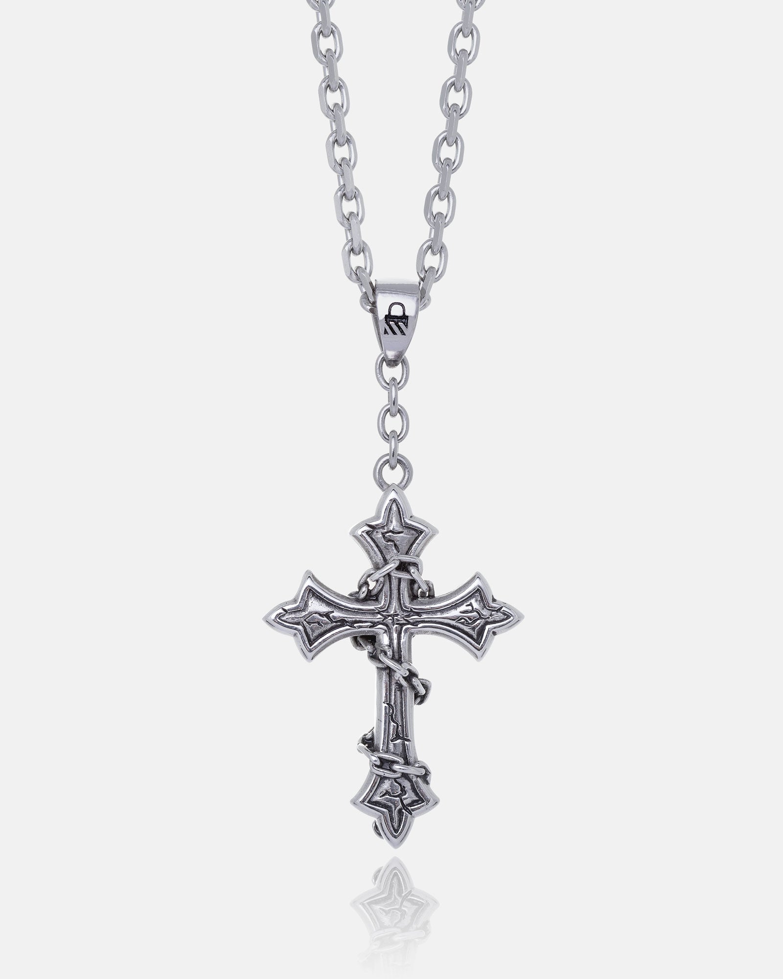 The Ruins" Pendant features an ornate, gothic cross with intricate detailing on a silver chain, shown against a white background. This large necklace is a bold statement piece for any collection.