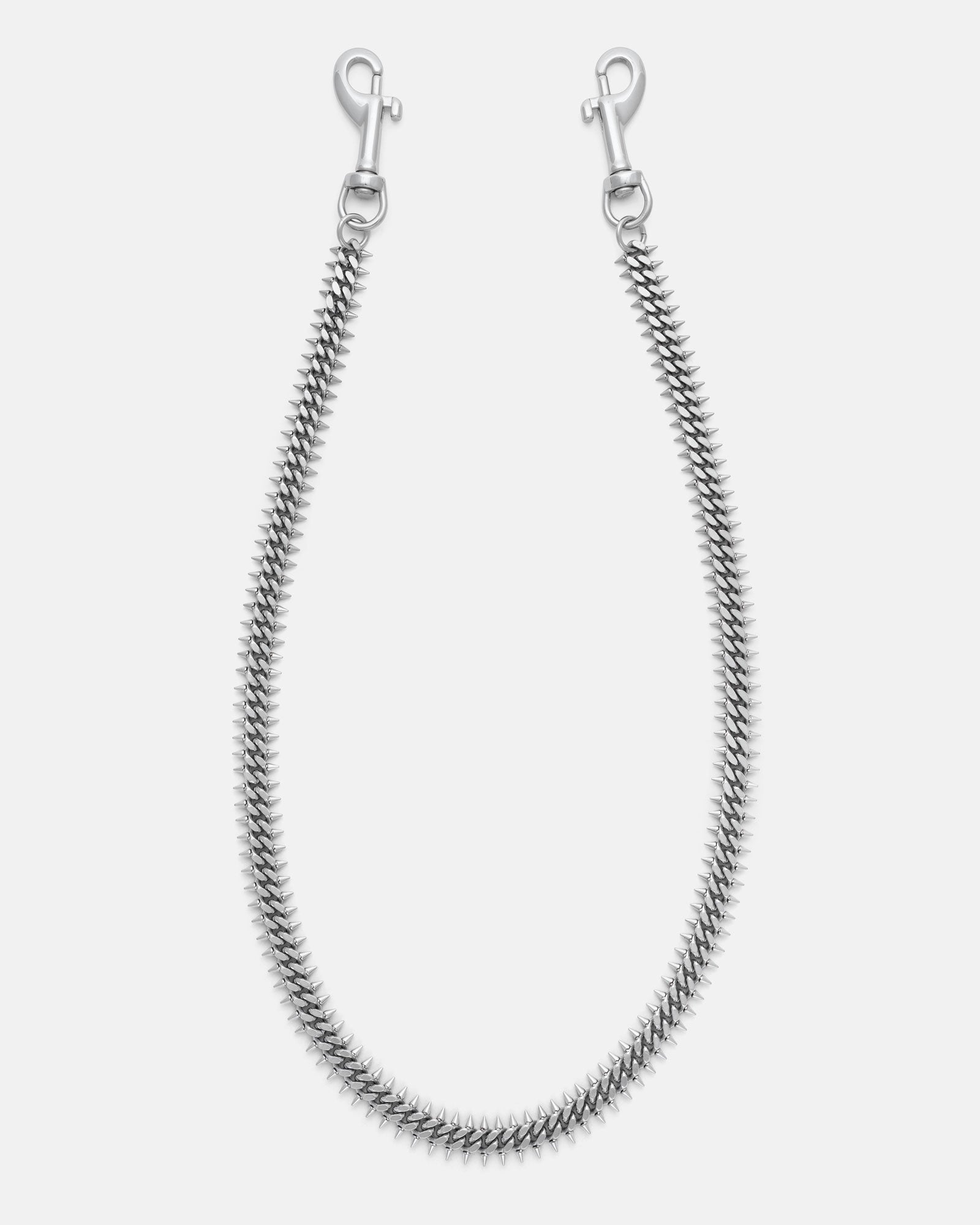 Silver spiked Cuban wallet chain with 2mm spikes on either side for a brutalist feel. Silver heavy duty hardware clips to hook onto you belt loops. on grey background.