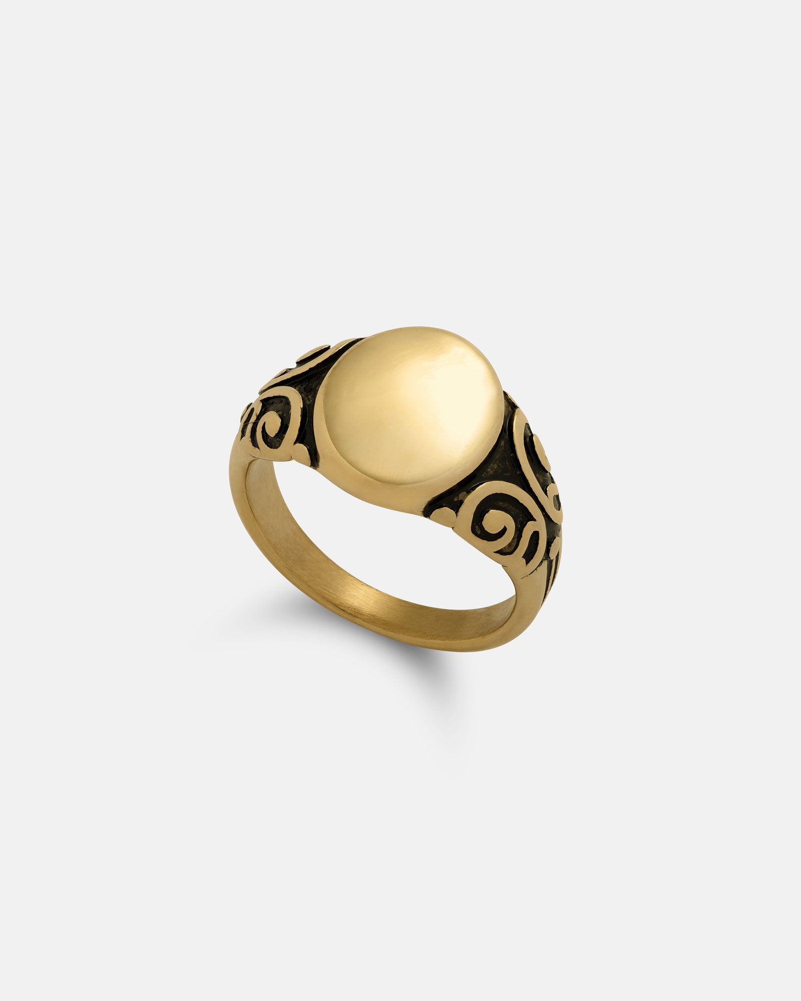The Mini Oval Scroll Signet Ring (Gold) features a smooth, oval face and detailed black scrollwork on the band, displayed on a plain, light background.