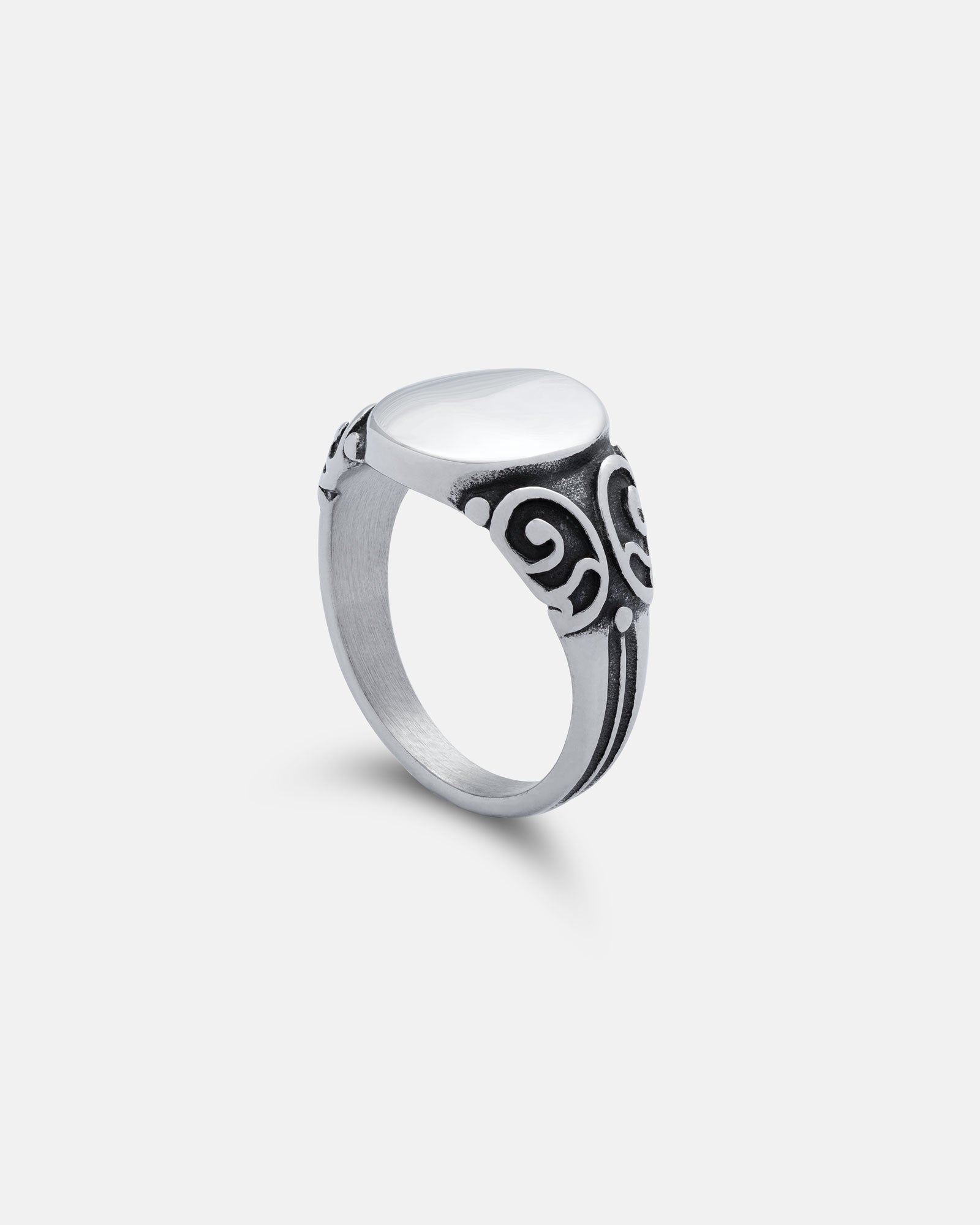 Silver ring with intricate design on a light gray background by statement