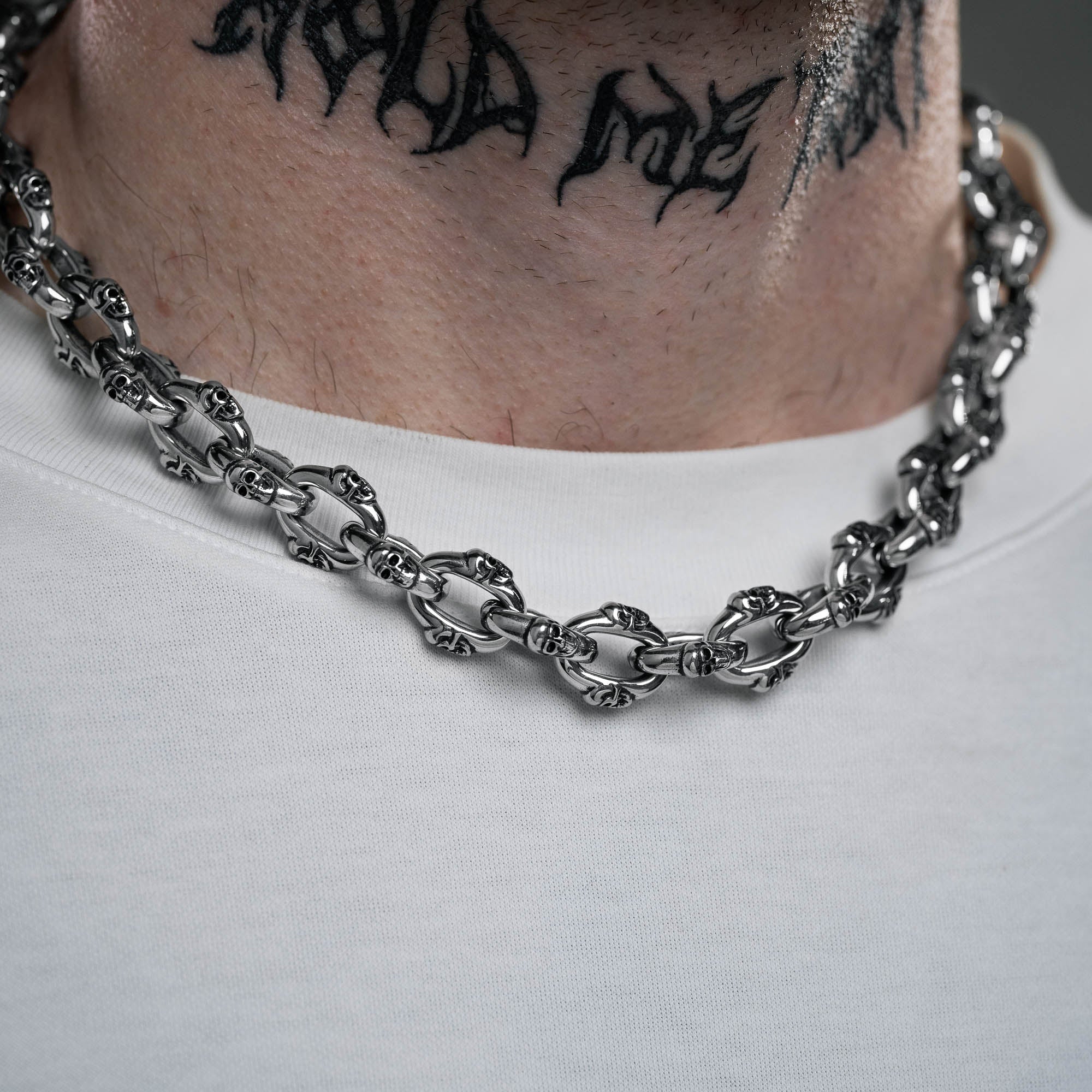 Silver Skull chain on male model with neck tattoo 