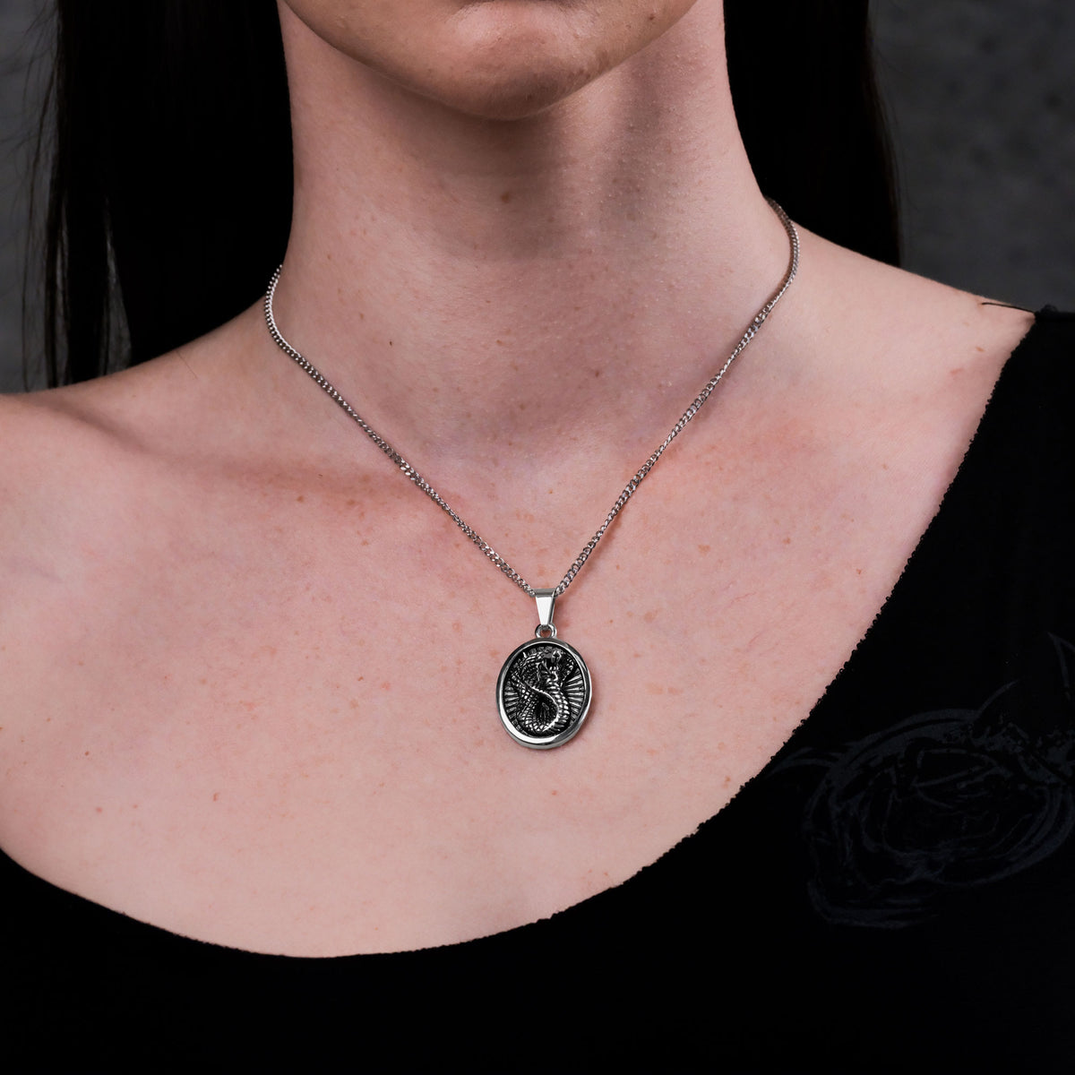 Women&#39;s snake charm necklace on body