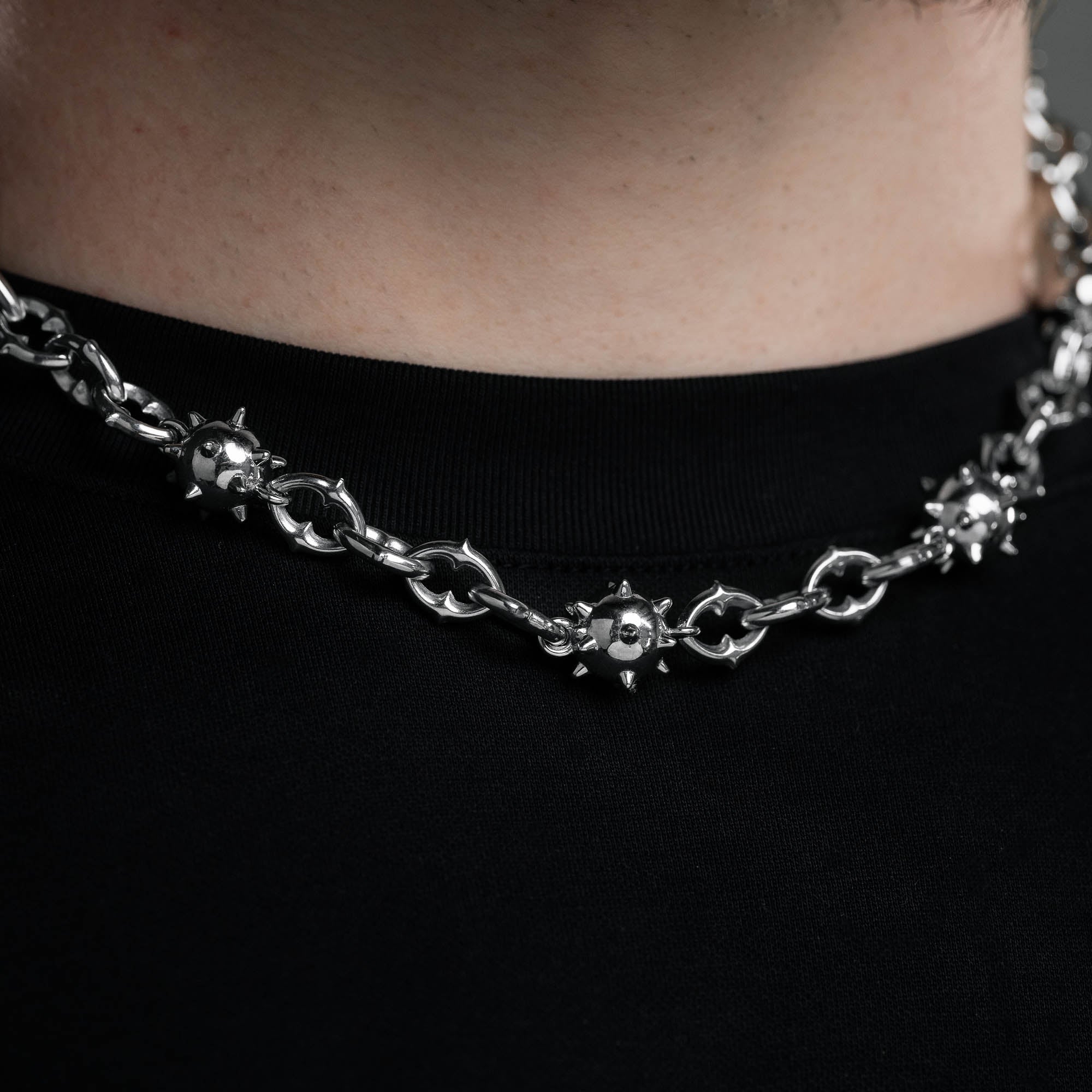 Close detailed shot of spiked ball necklace chain with unique spiked chain links by statement collective
