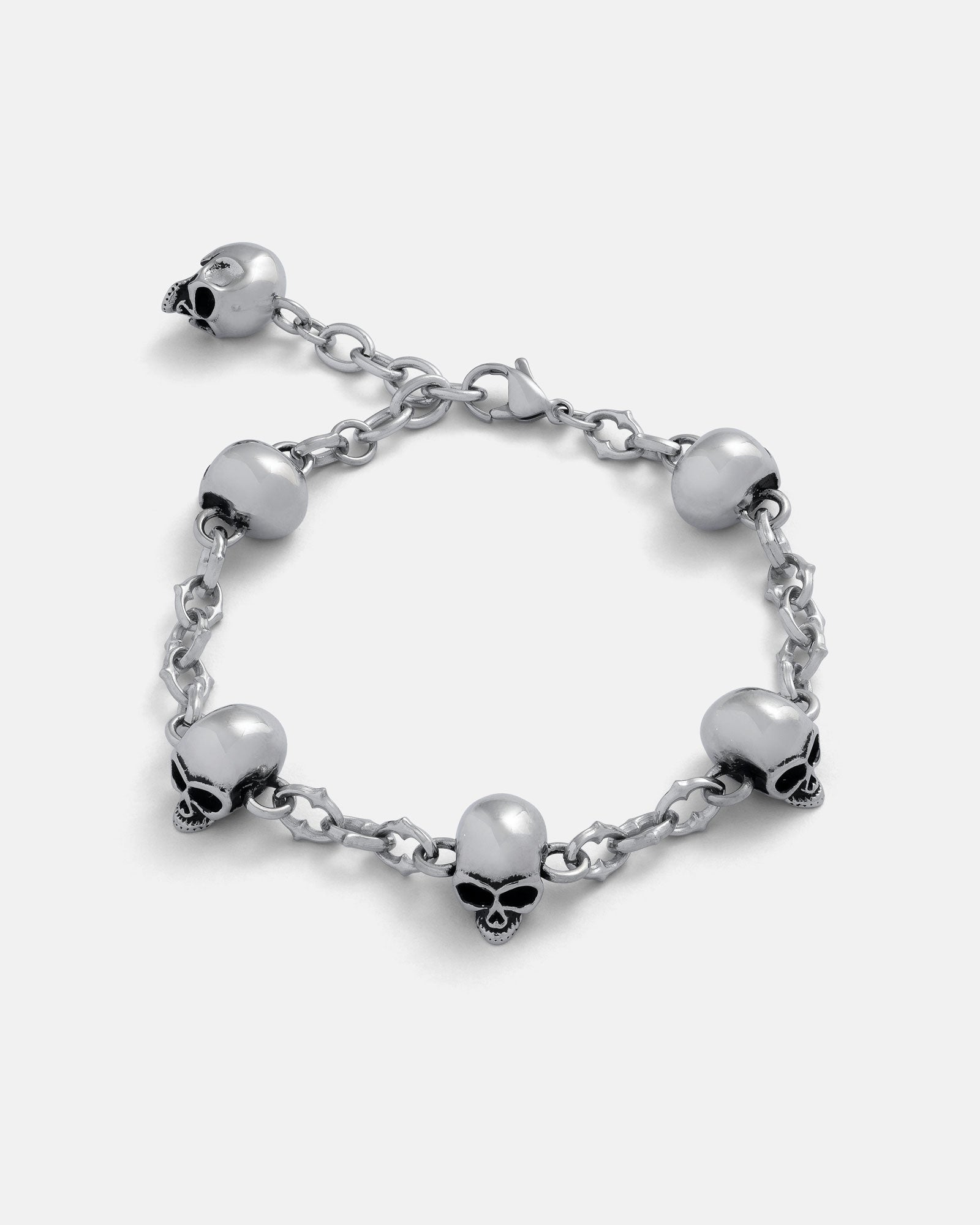 Silver 6mm Cathedral chain bracelet with skull charms around and a 2.5cm Extender by statement collective on grey background. 