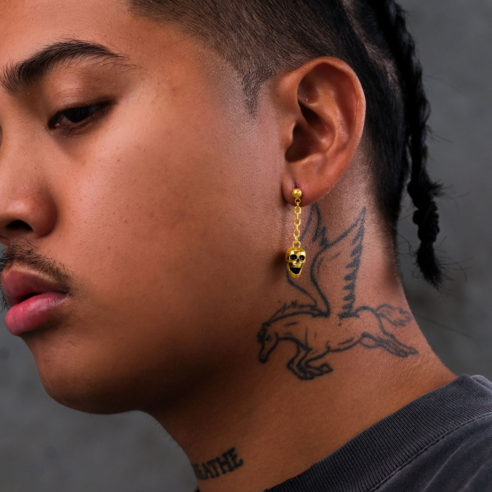 Men's gothic earrings on body with skull charm