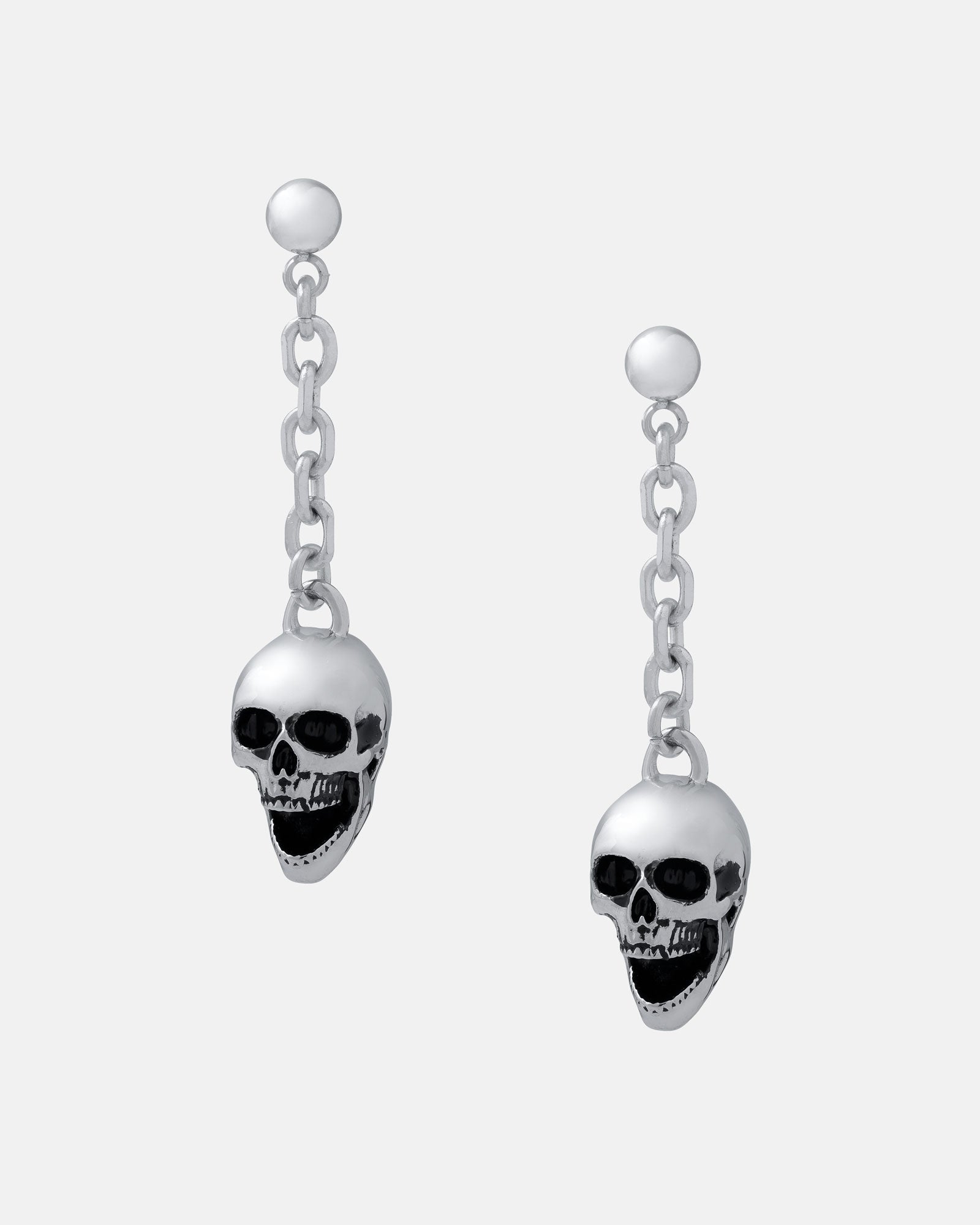The Skull Drop Earrings are rock-themed silver dangle earrings with chain links and detailed skull charms, crafted from hypoallergenic stainless steel and shown on a plain light gray background.