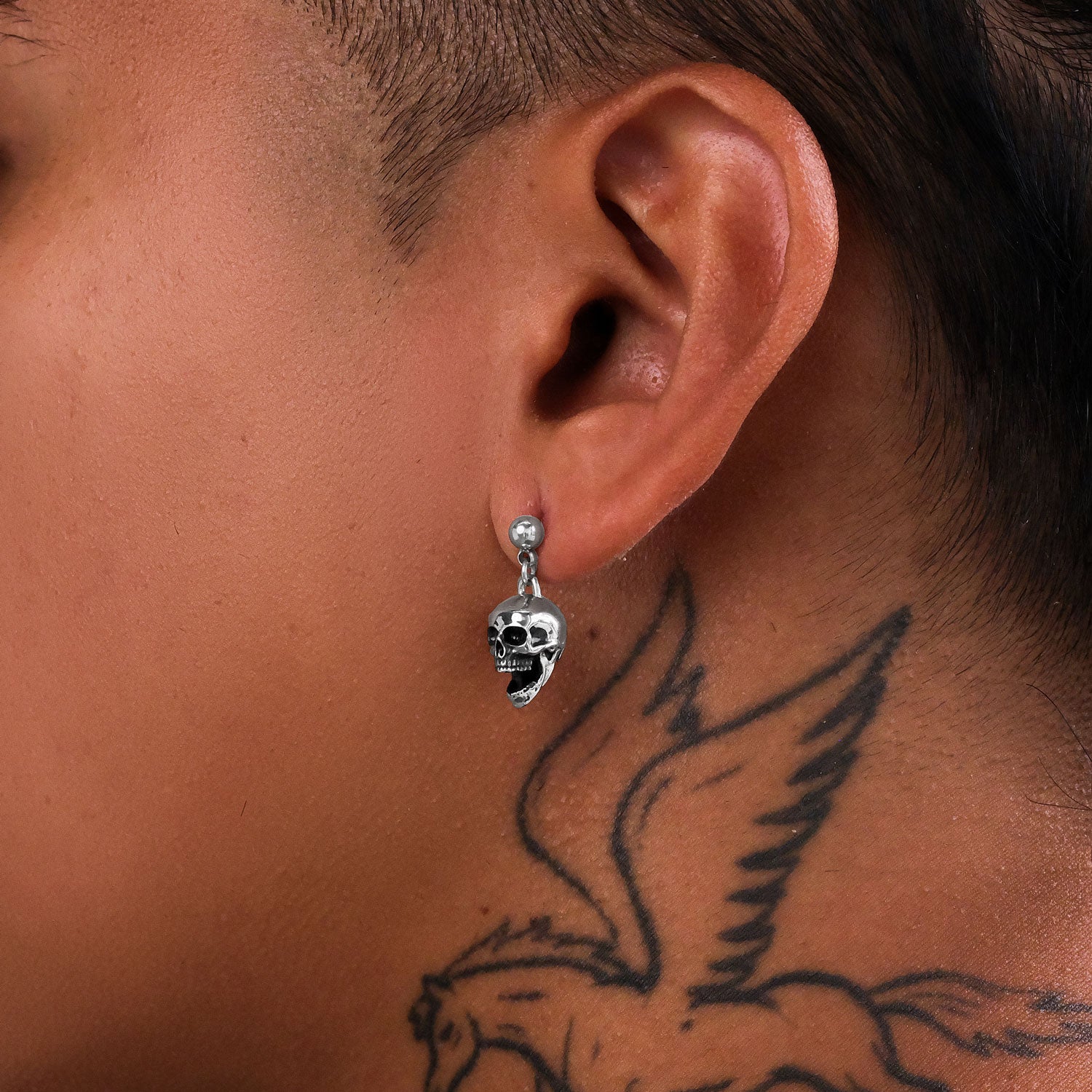 Men's skull earrings on ear