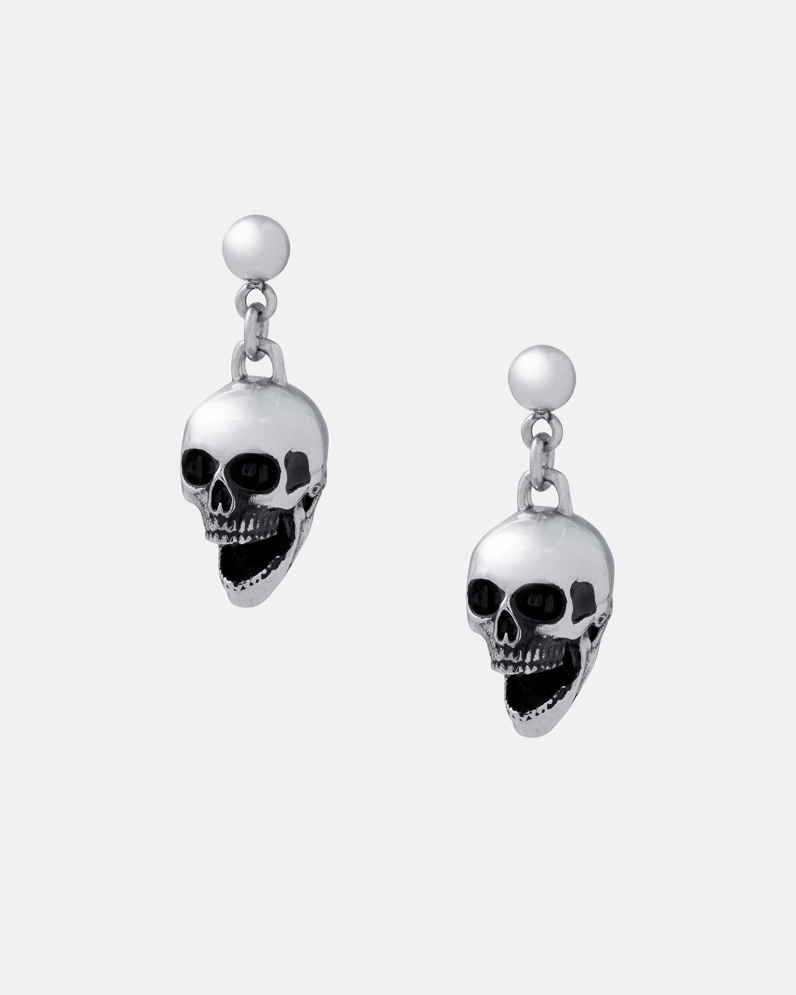 Skull Earrings: Silver dangle earrings with detailed skull charms and black accents, made from hypoallergenic stainless steel—ideal for adding a bold edge to your rock fashion look. Shown on a plain white background.