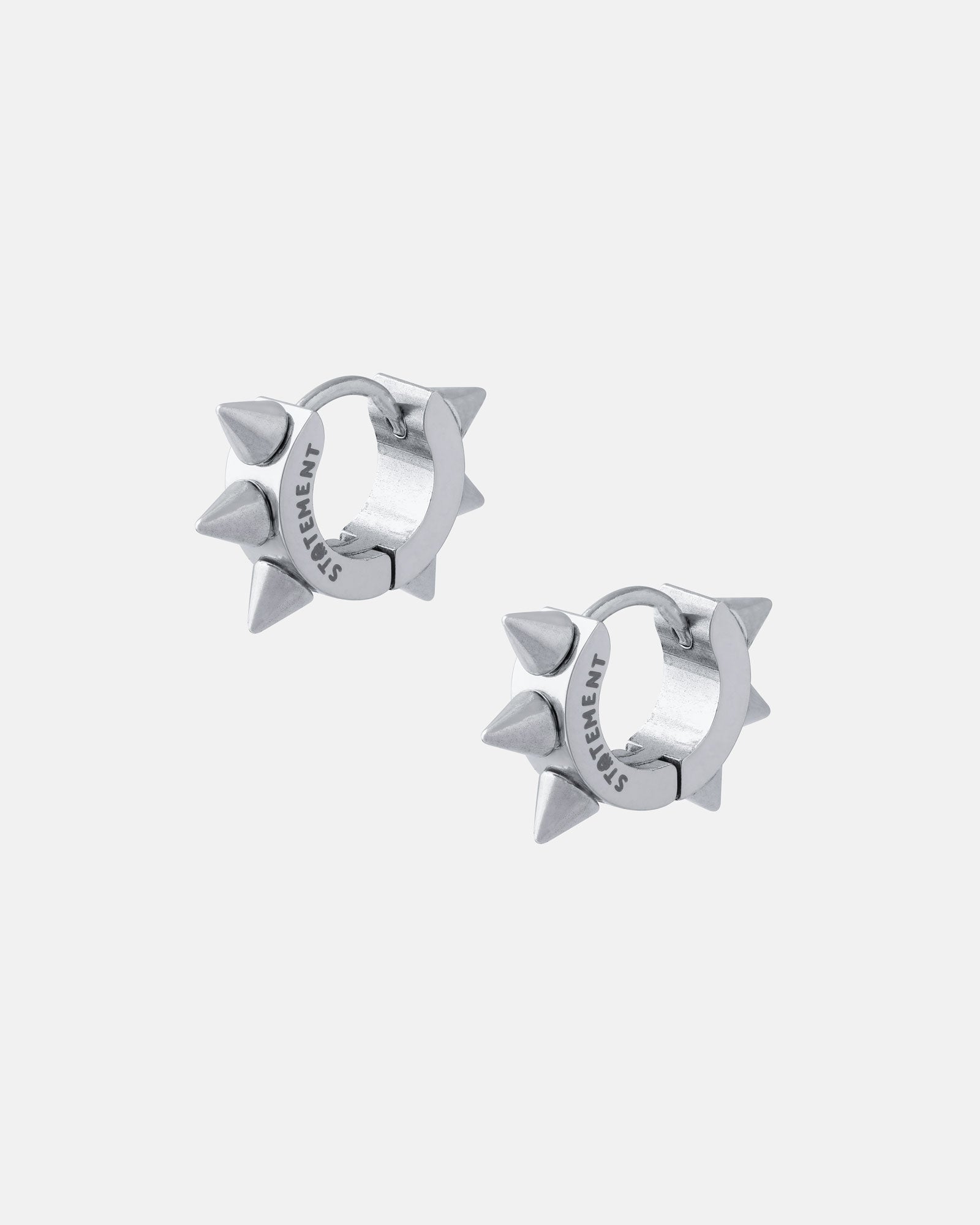 A pair of 6mm Spiked Hoop Earrings (Gold), each with three evenly spaced pointed spikes and "STATEMENT" engraved on the inner edge, displayed against a plain light gray background.