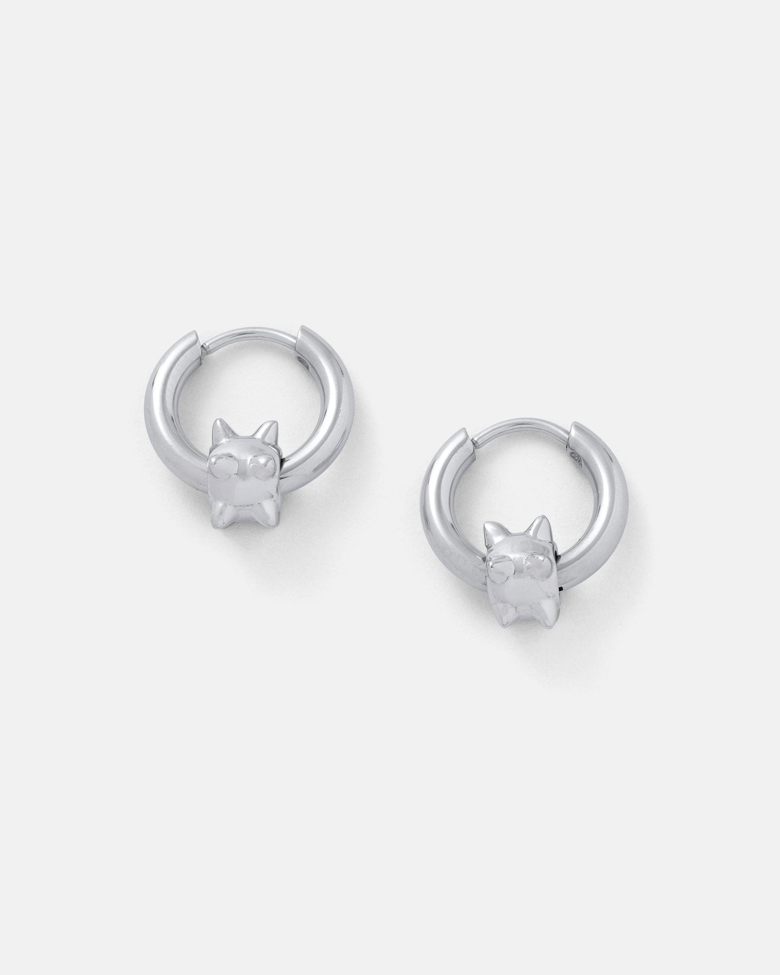 A pair of "Morning Star" silver waterproof hoop earrings, each adorned with a small cat head charm with pointed ears, displayed on a plain white background.