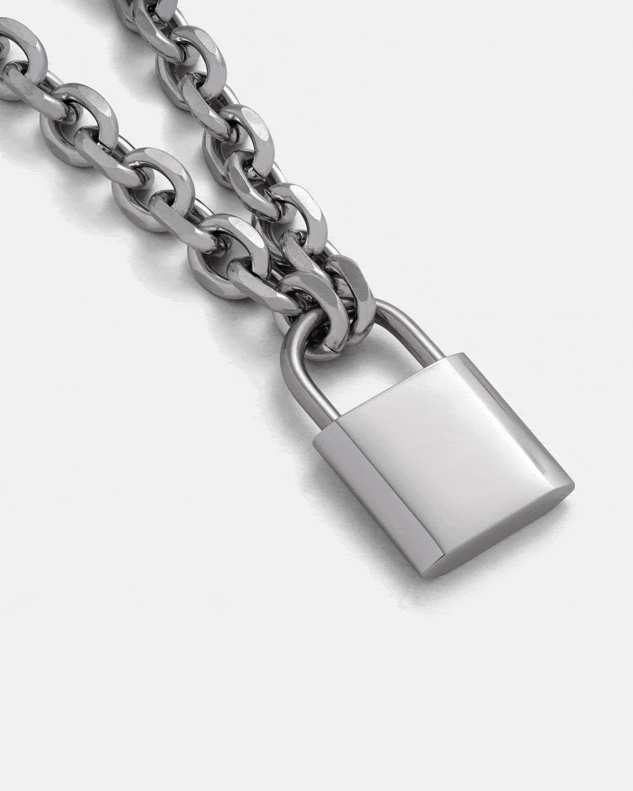 A close-up of the Statement Collective Statement Lock & Chain 2.0 silver necklace, showcasing its shiny padlock pendant—perfect statement jewelry displayed against a plain light background.