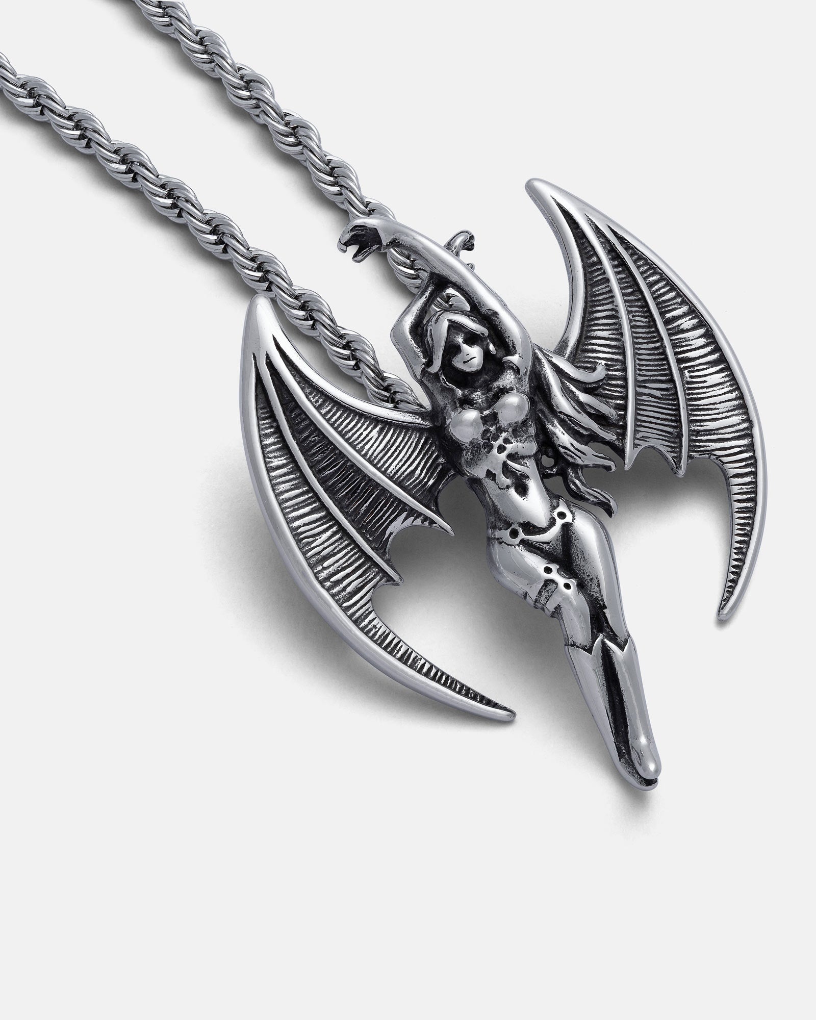 The Enchantress" Pendant is a silver necklace featuring a detailed, hand-carved winged female figure with bat-like wings, one arm raised holding the chain. This intricately designed pendant has a polished finish.