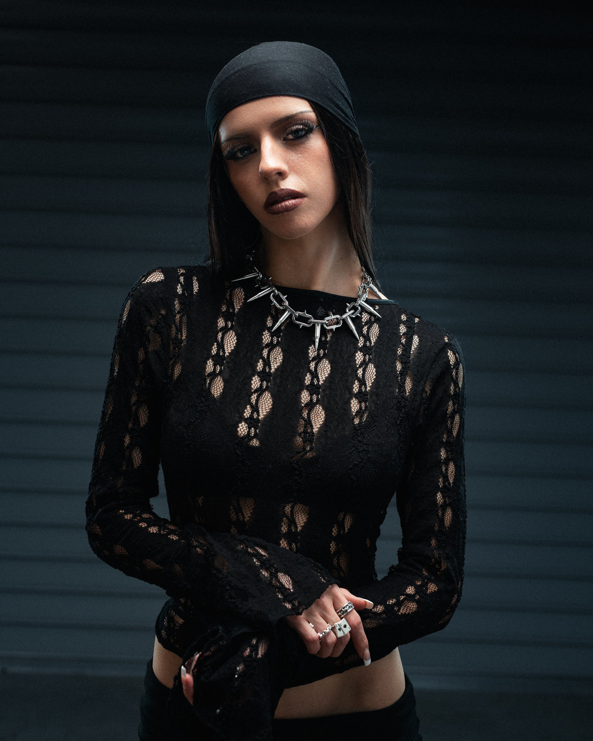 A person wearing a Sweating Bullets Necklace Chain made of heavy stainless steel with a black lace top.