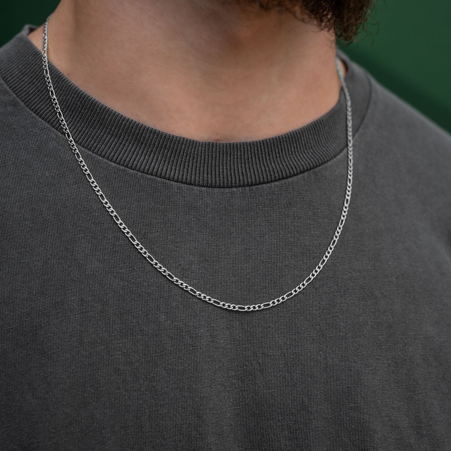 silver figaro chain necklace on mens neck