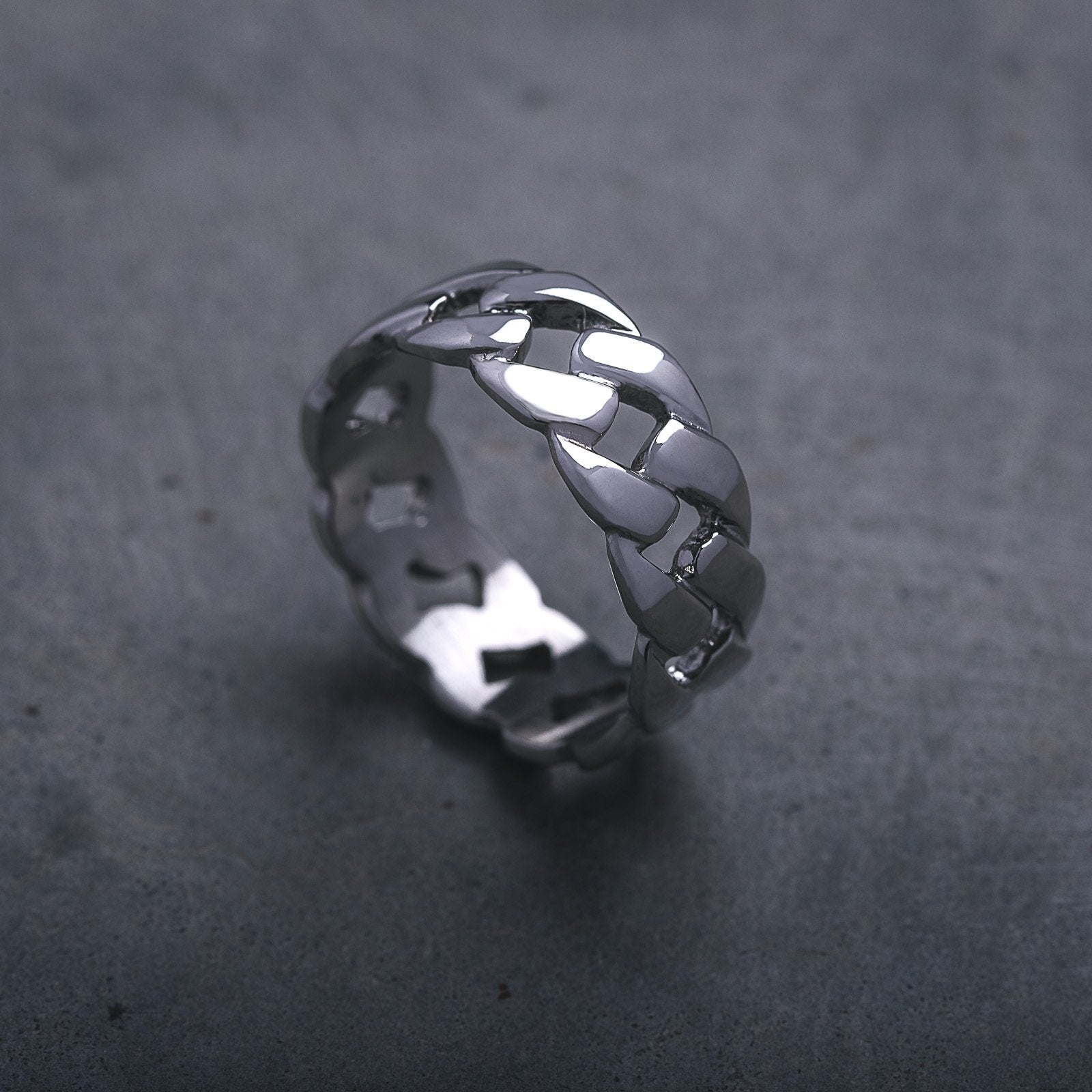 cuban link pattern ring silver on cement background by statement