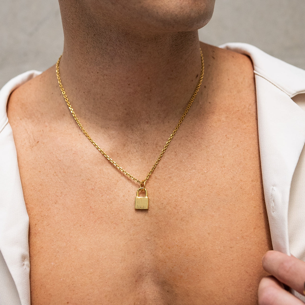 Mens gold padlock pendant necklace on body