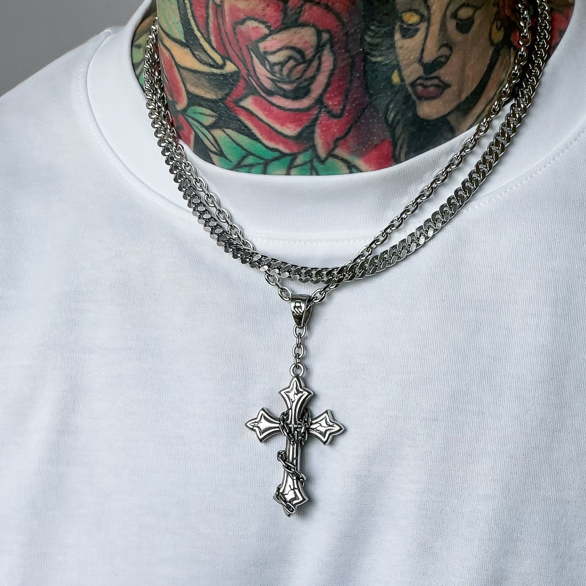 Cross pendant layered with cuban chain